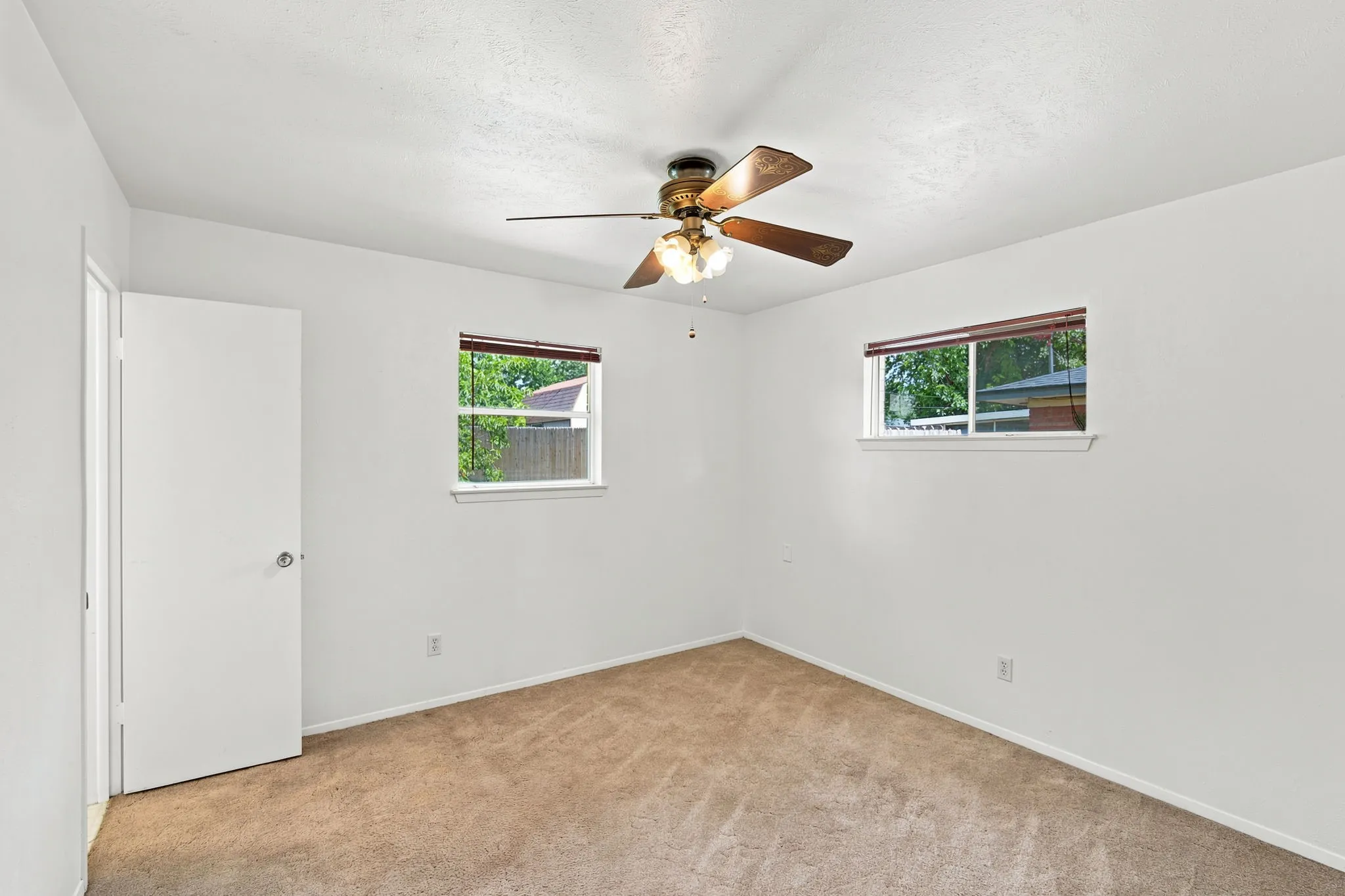 Neutral-toned carpeted room featuring white walls and trim