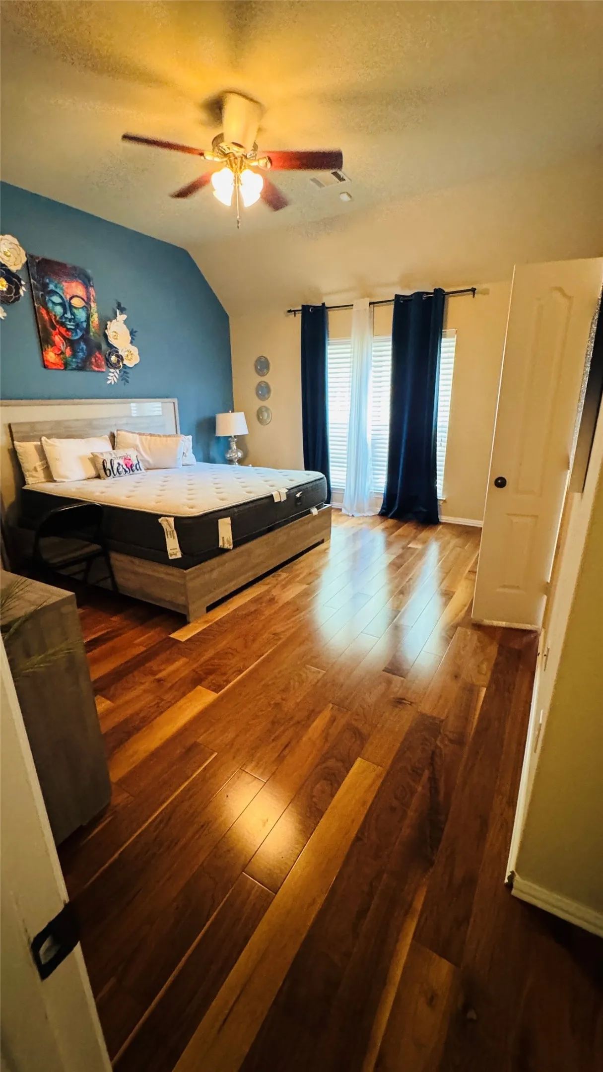 Wood-finish flooring, vaulted ceiling, and ceiling fan with integrated lighting