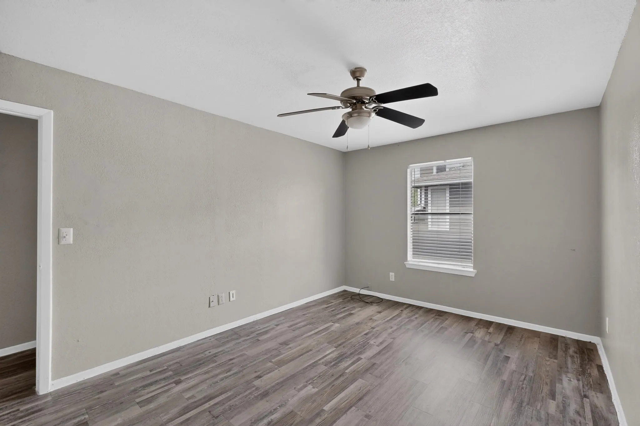 Room featuring wood-finish flooring, light gray walls, and white baseboards