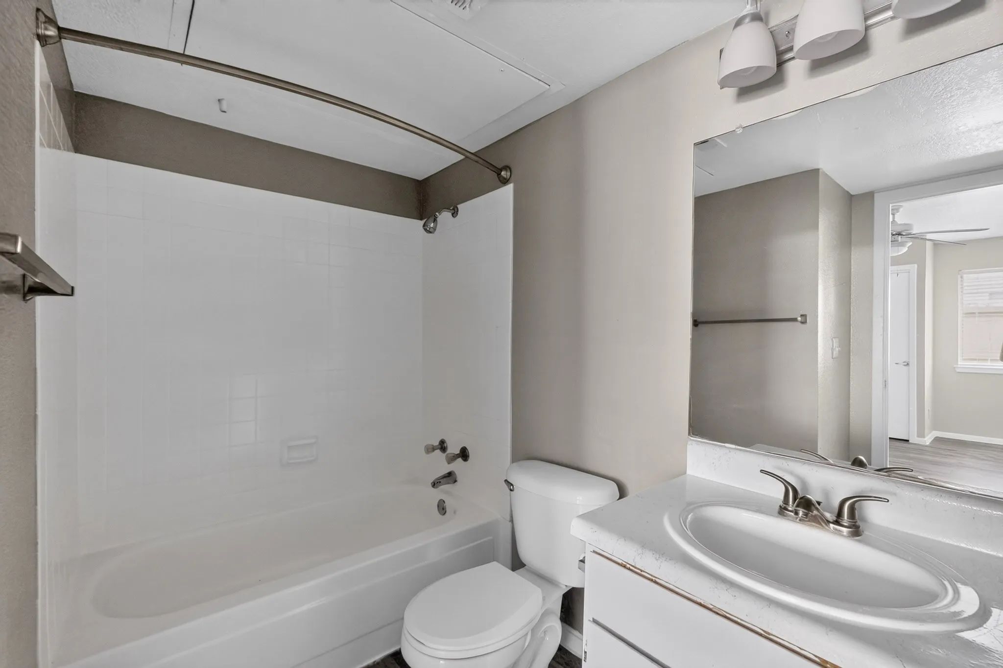 Bathroom featuring a white vanity with an integrated sink, brushed nickel faucet, and an overhead lighting fixture