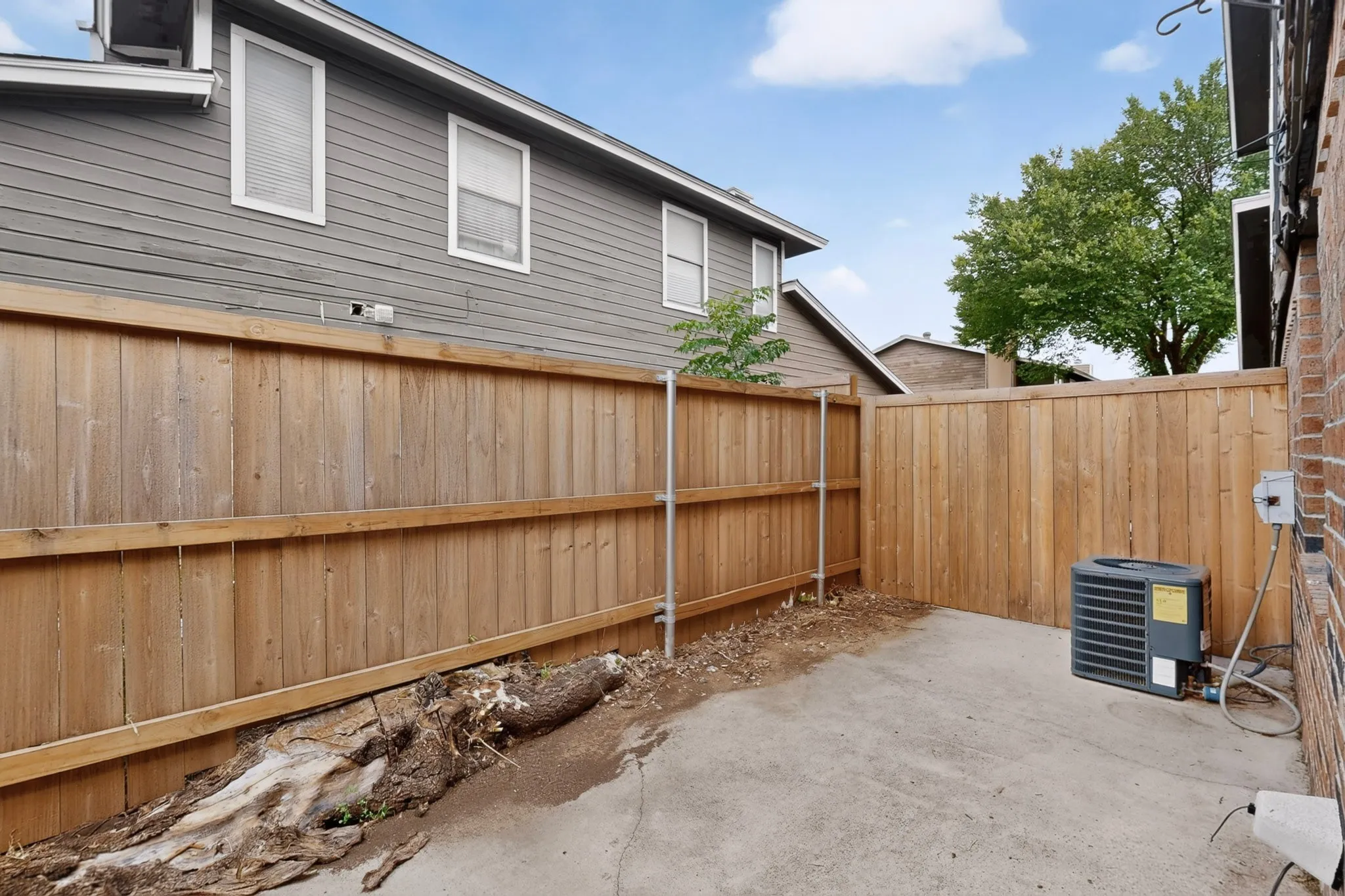 Private outdoor space featuring concrete paving and wood fencing