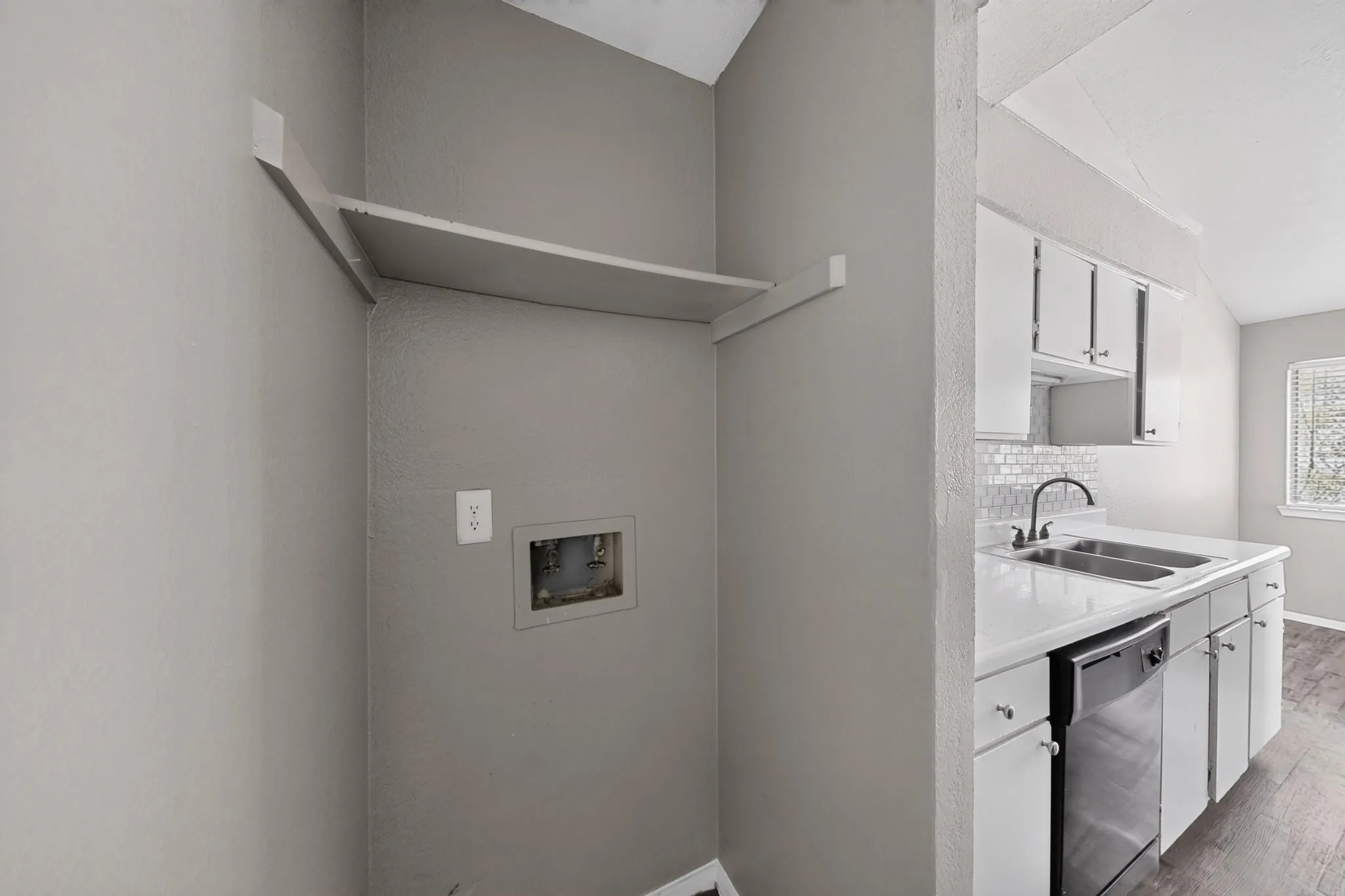 Dedicated utility alcove with integrated shelving and wall outlet