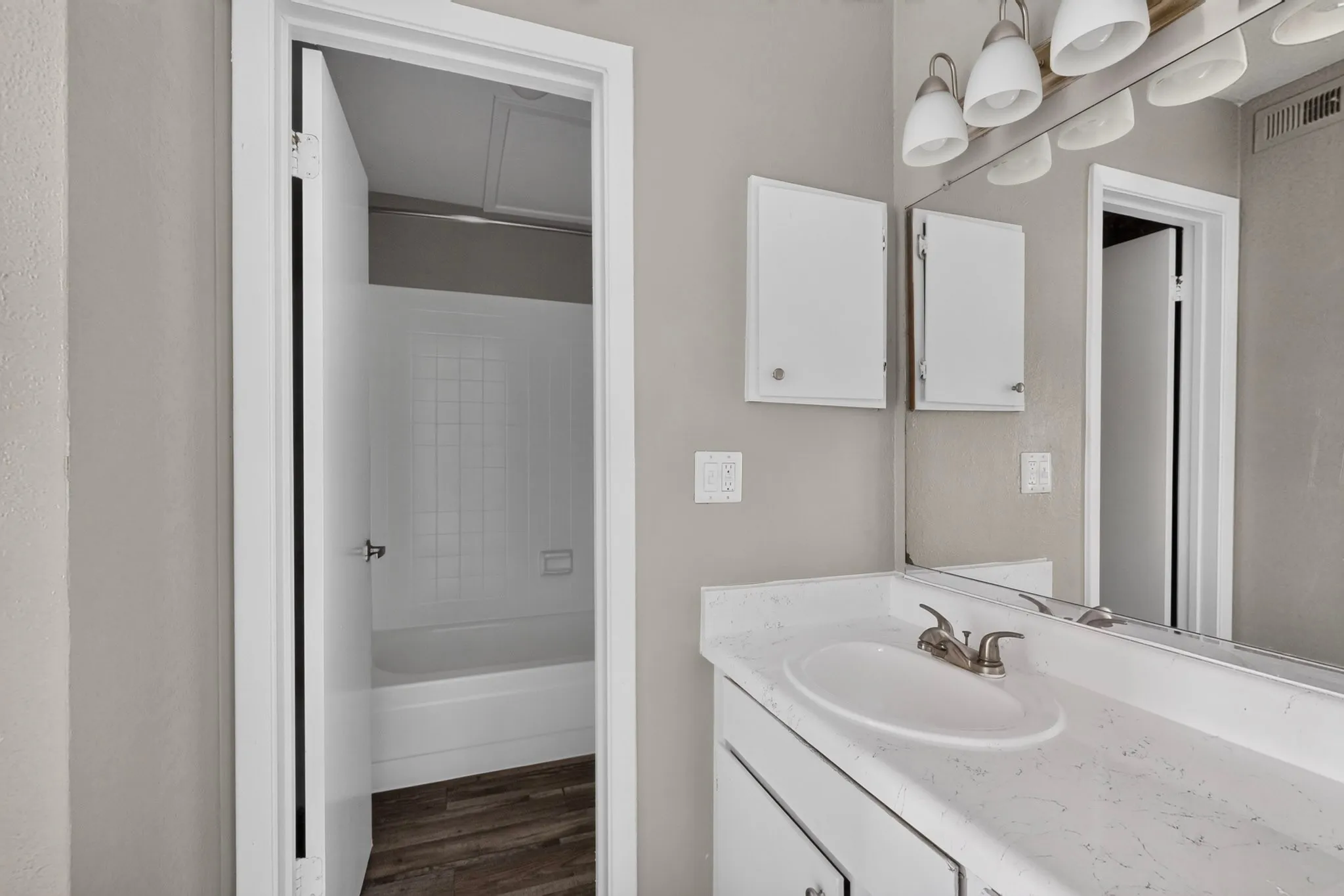 Bathroom vanity featuring a single basin, brushed nickel faucet, and a large mirror