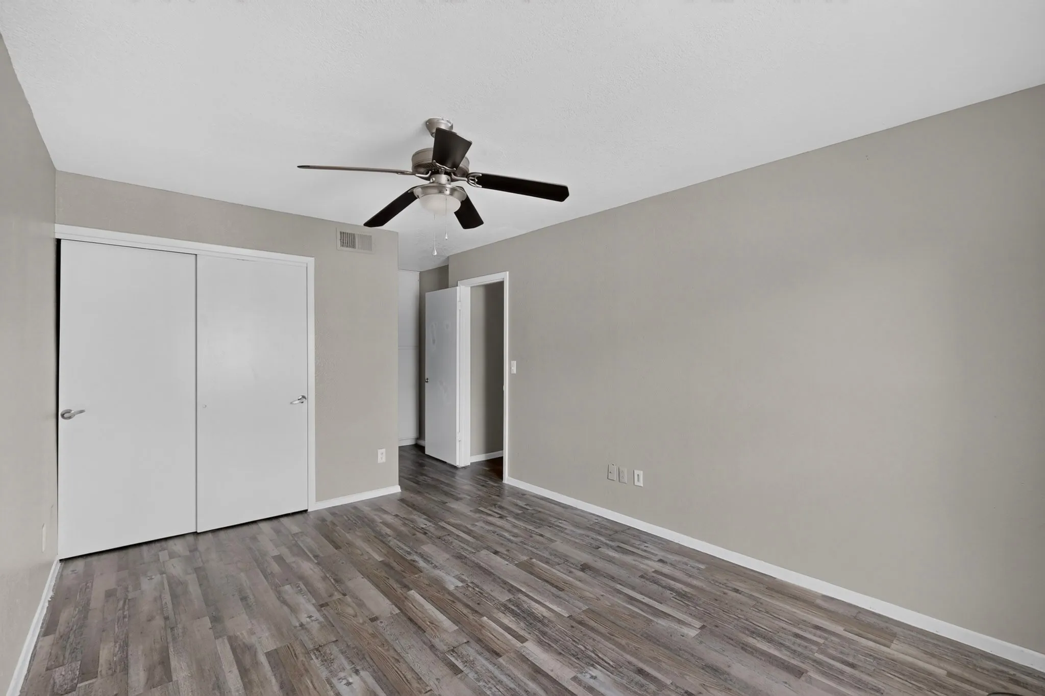 Neutral-toned room featuring plank wood-finish flooring