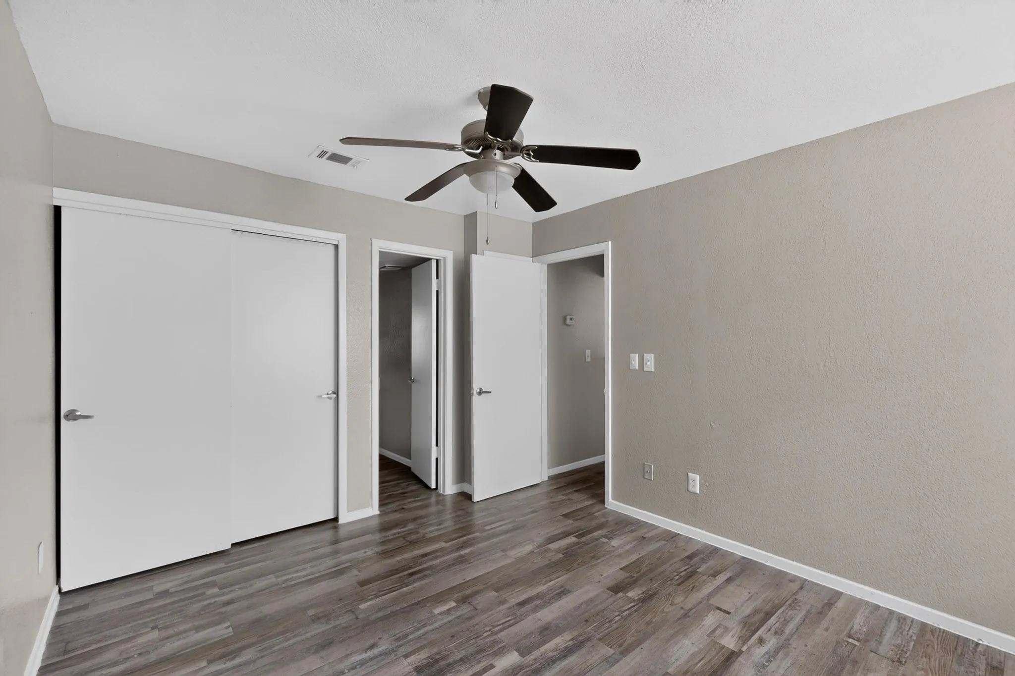 Room featuring wood-finish flooring, neutral wall tones, and white trim