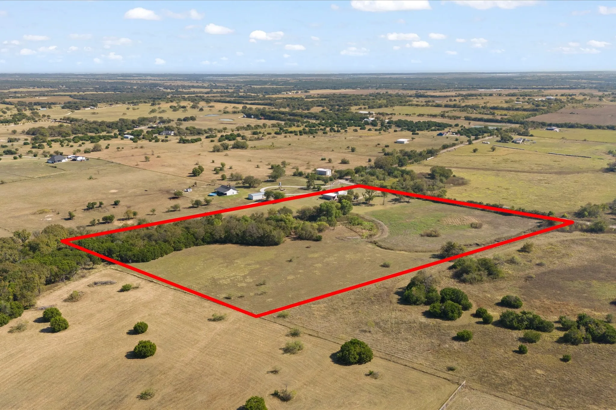 Expansive acreage featuring a mix of open fields and mature tree lines