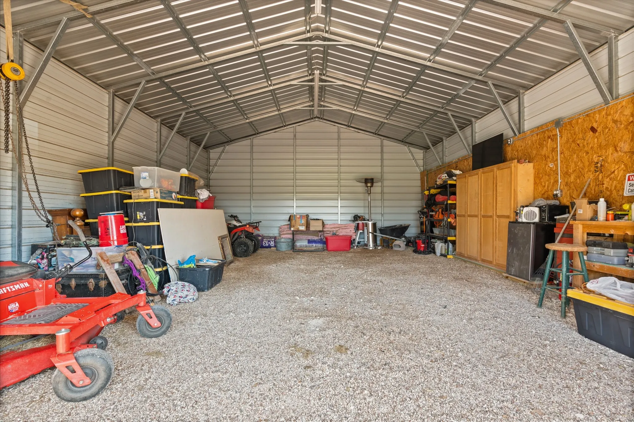 Spacious metal outbuilding featuring a corrugated metal roof, corrugated metal siding, and a gravel floor