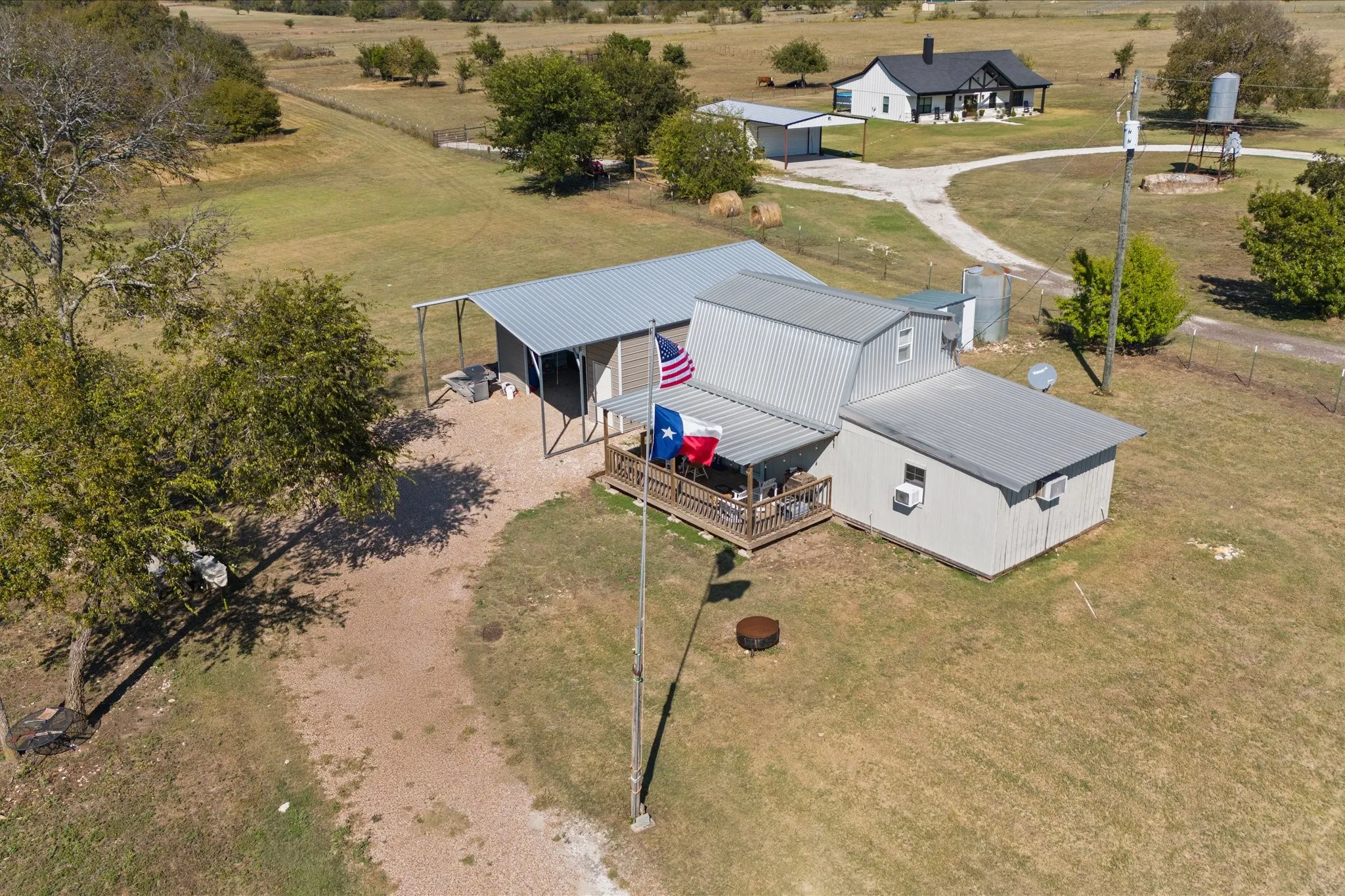 Barn-style structure with a covered porch and gravel driveway