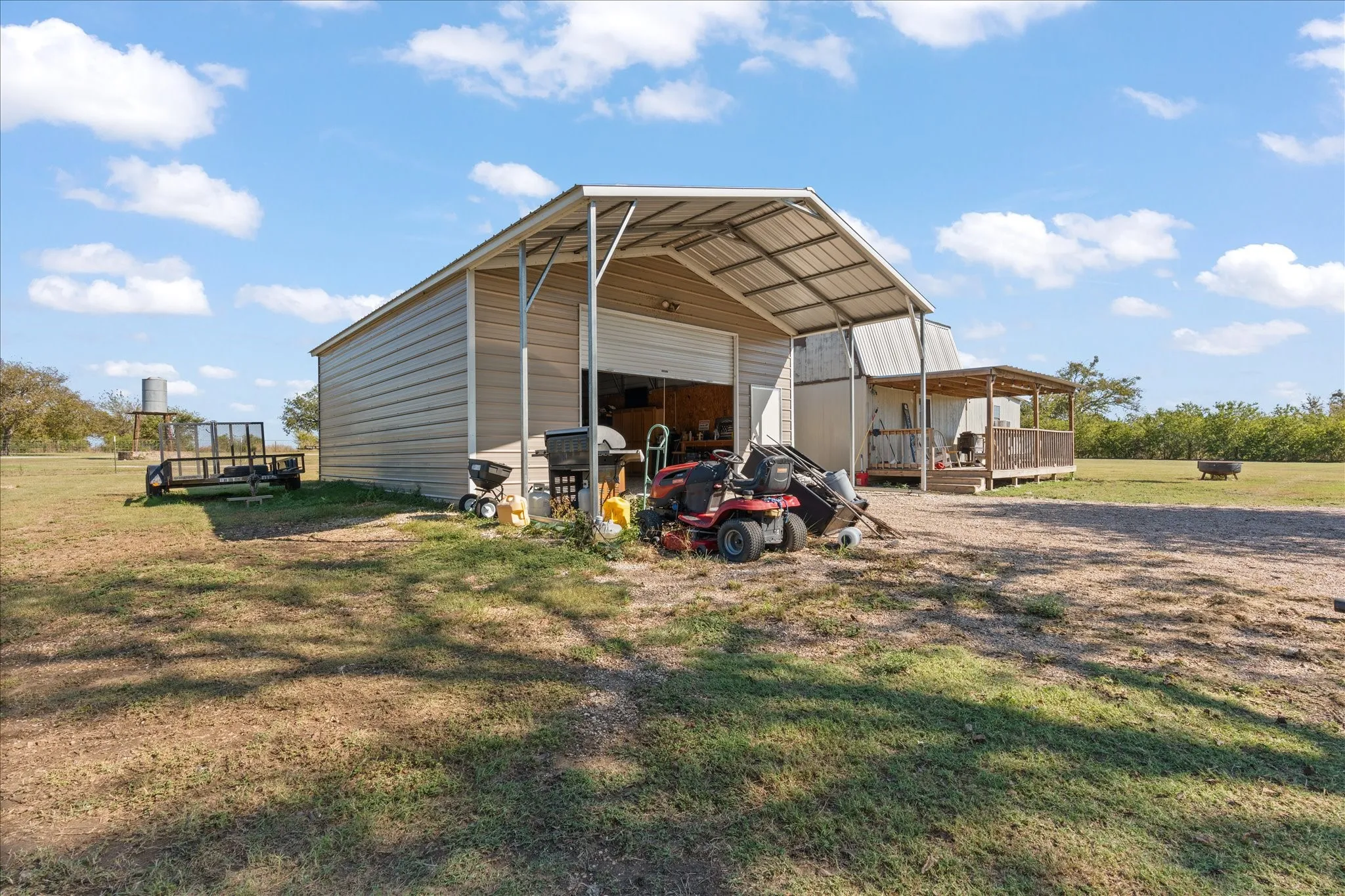 Metal-sided barn structure with a large open bay and an extended covered porch