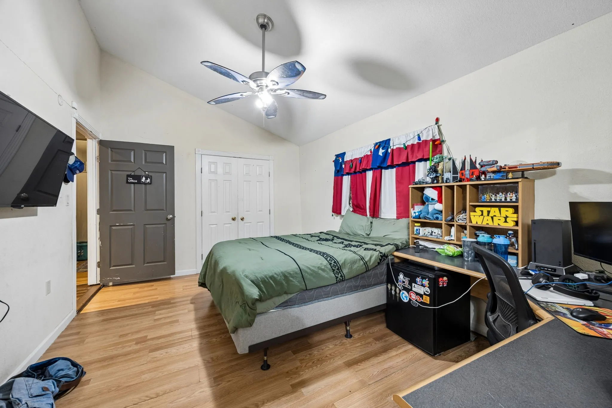 Vaulted ceiling bedroom with wood-finish flooring