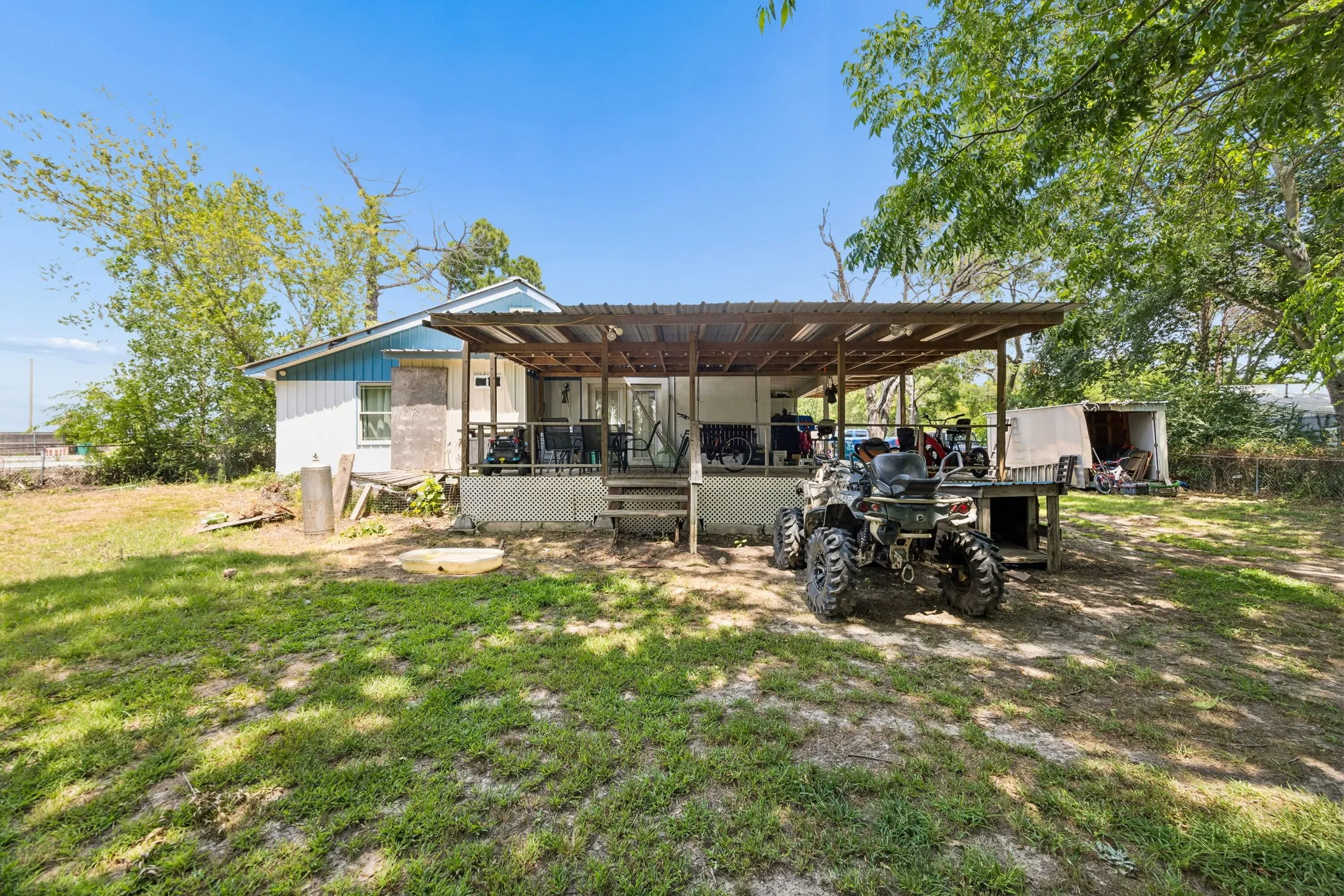 Expansive rear yard featuring a covered porch with a corrugated metal roof