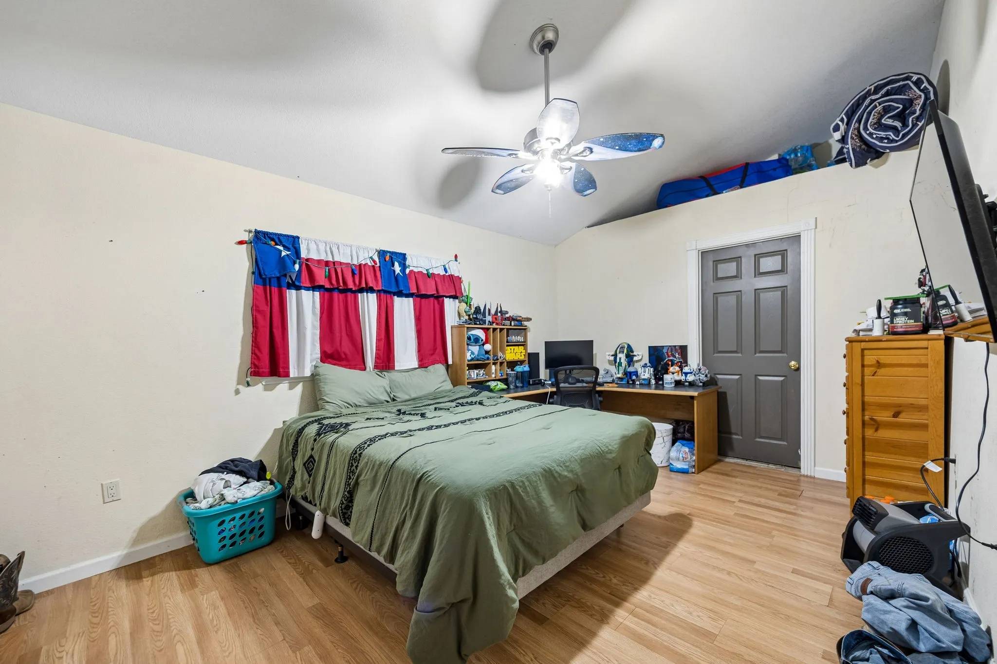 Bedroom featuring wood-finish flooring, vaulted ceiling, and a ceiling fan with integrated lighting