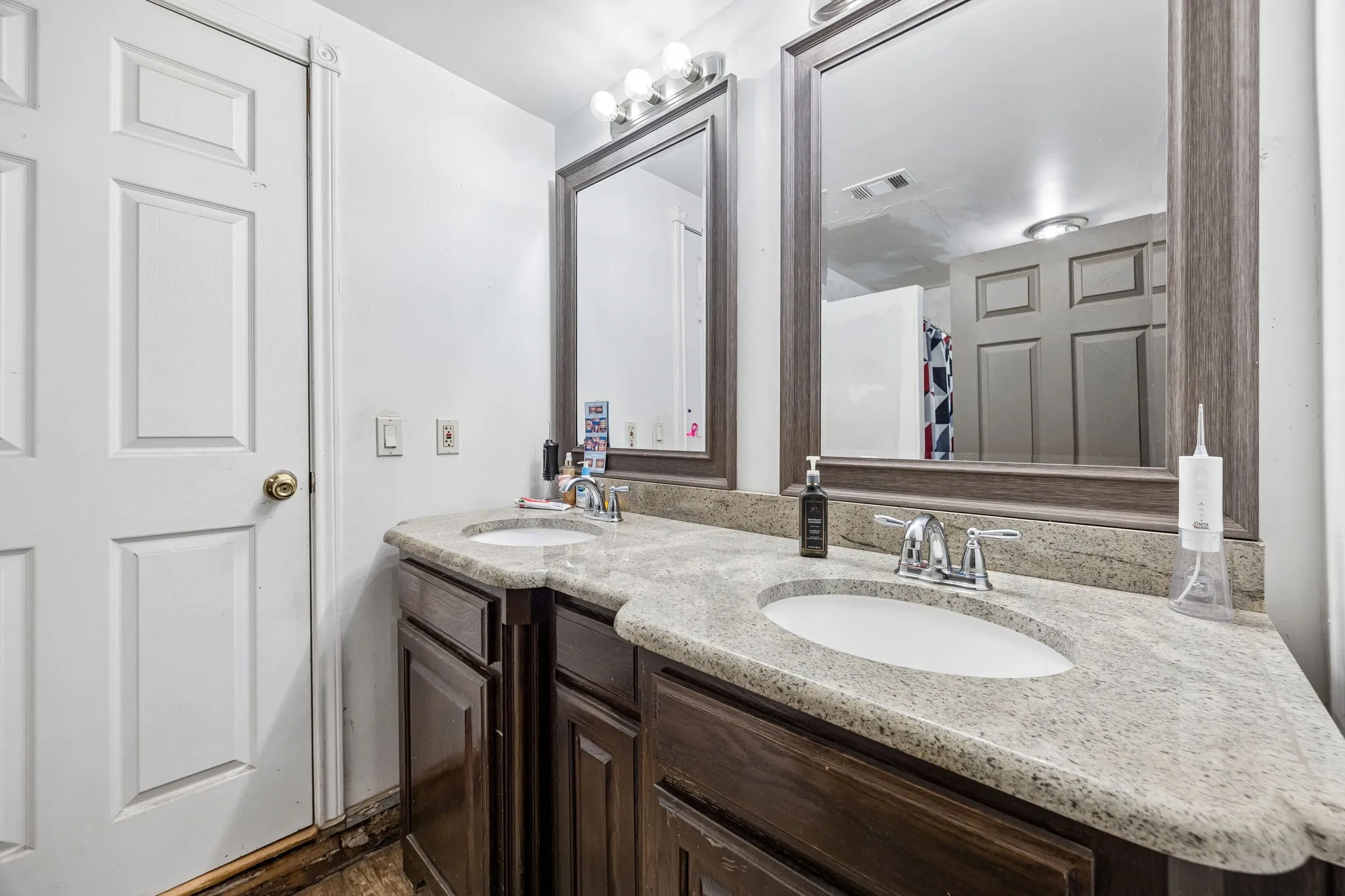 Double vanity with granite-finish countertops, undermount sinks, and chrome fixtures