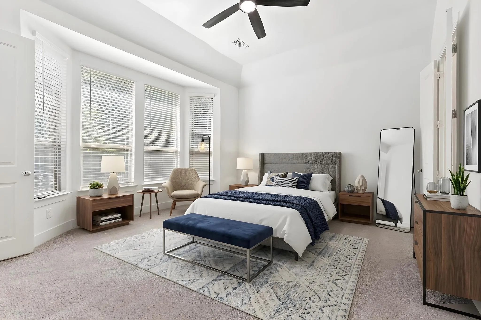 Virtually staged primary bedroom with ceiling fan and carpet.