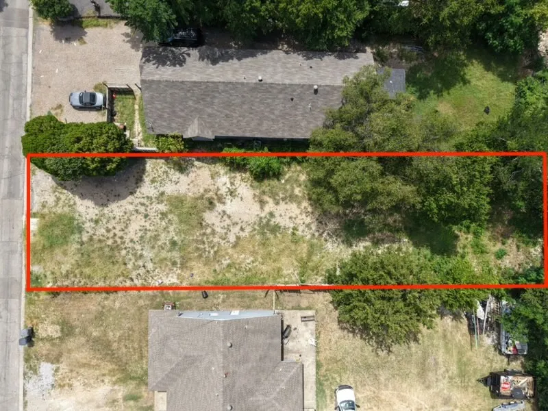 Rectangular lot with partial tree coverage, featuring a clear, level building area