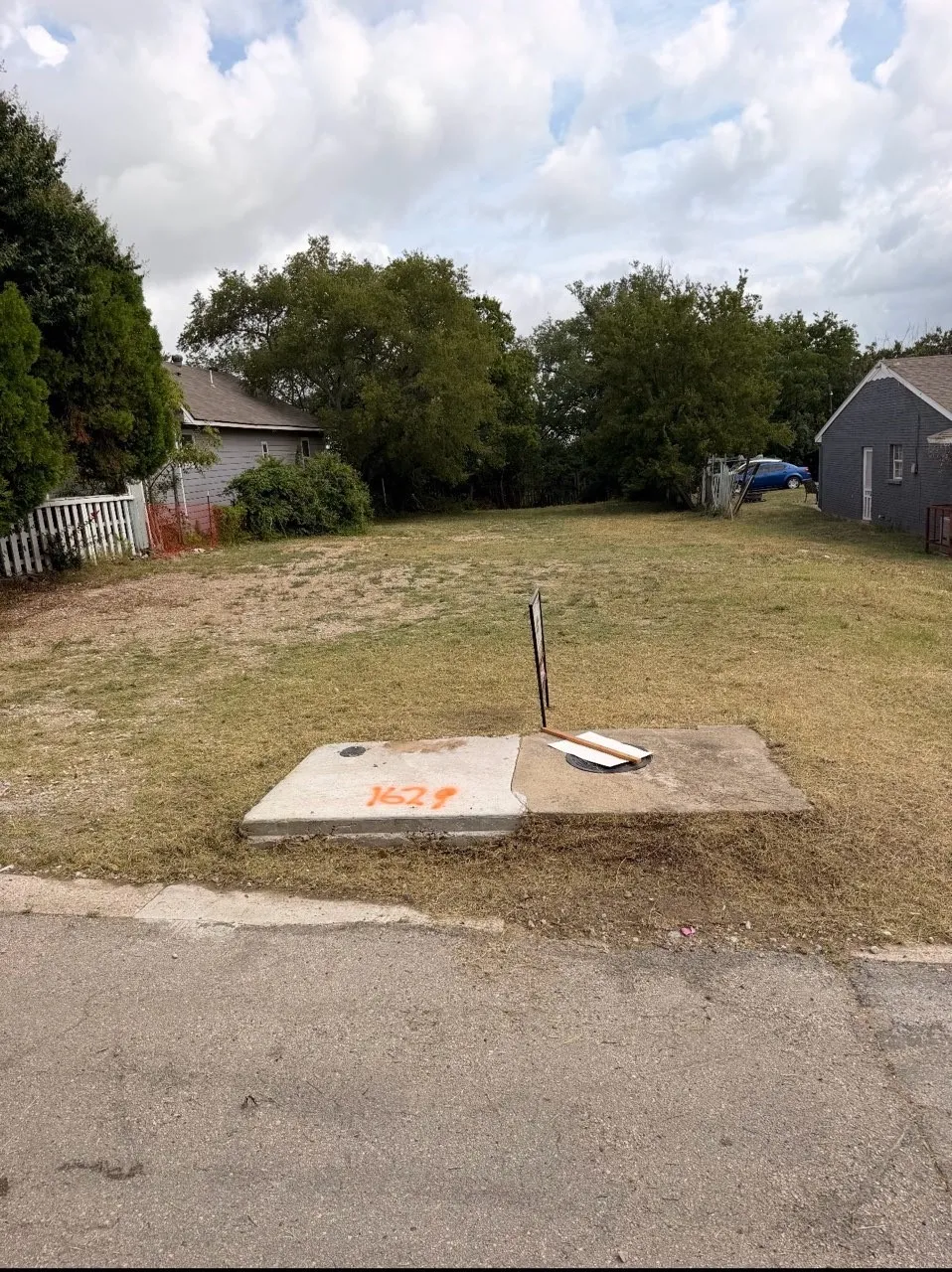 Grassed lot with established trees and a paved street frontage