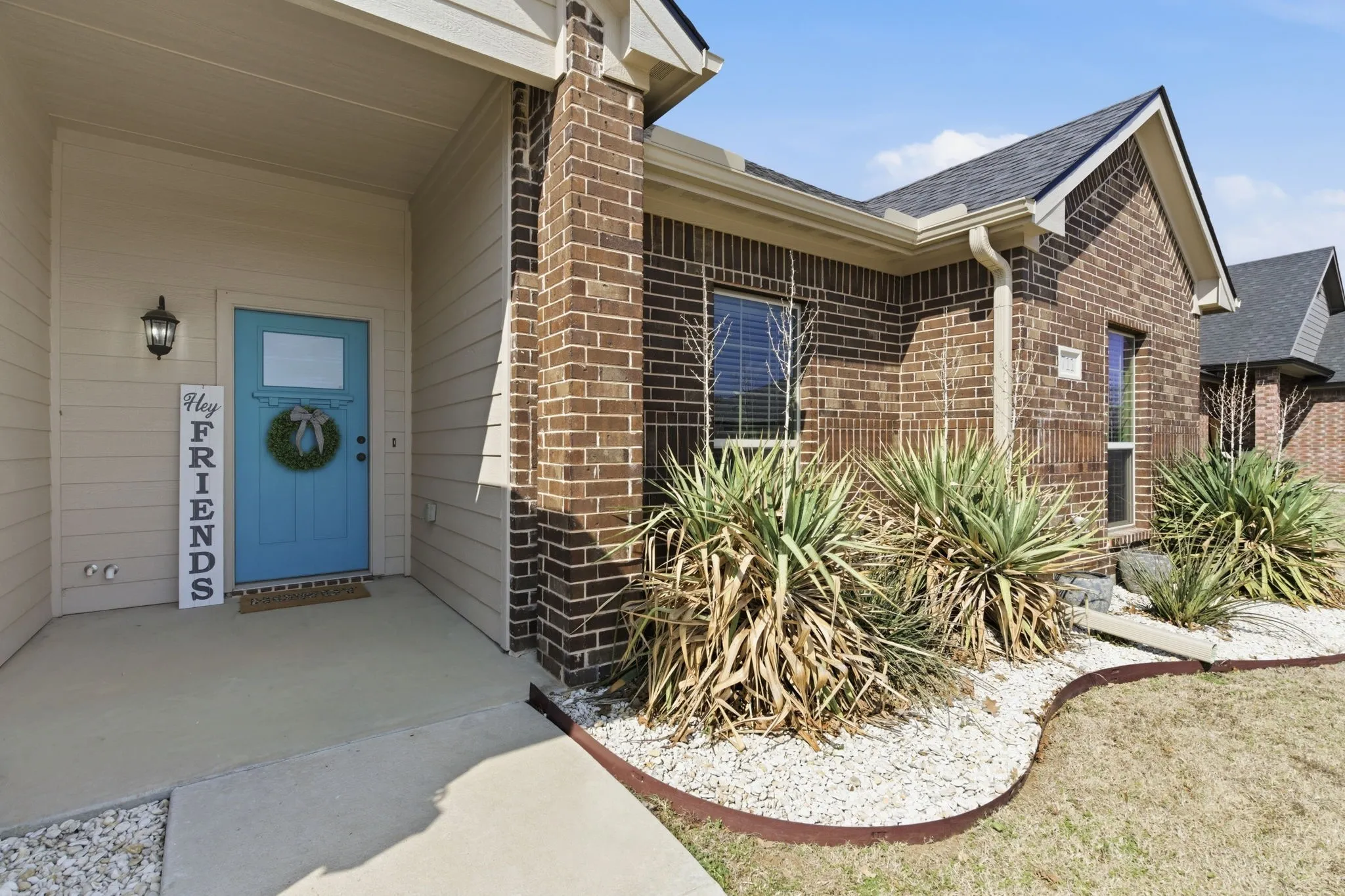 Entrance to property featuring brick siding and roof with shingles