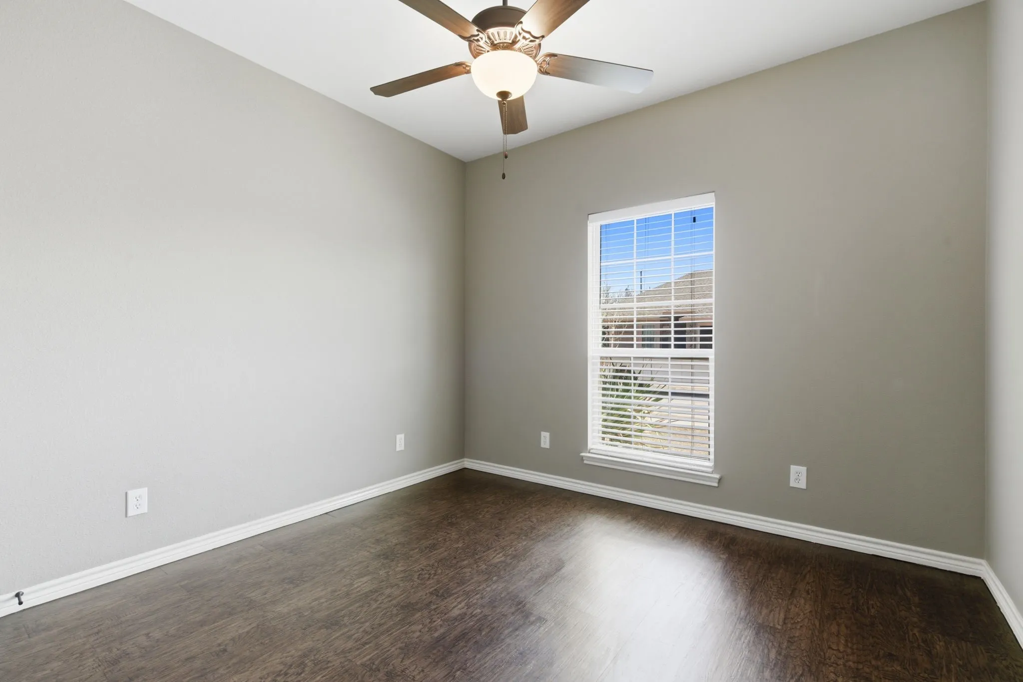 Spare room with a ceiling fan and dark wood finished floors