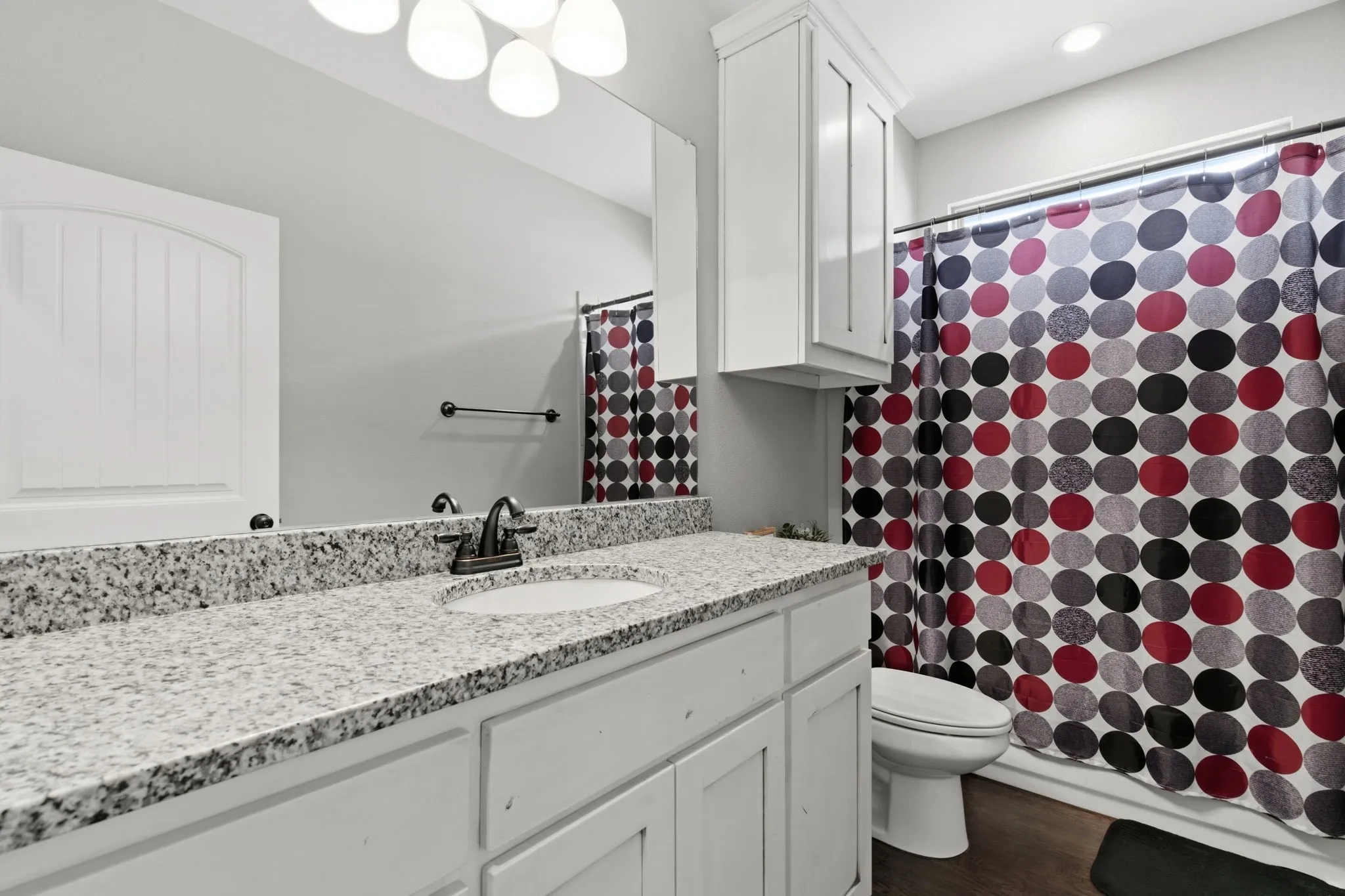 Bathroom with vanity, a shower with shower curtain, and dark wood-style flooring