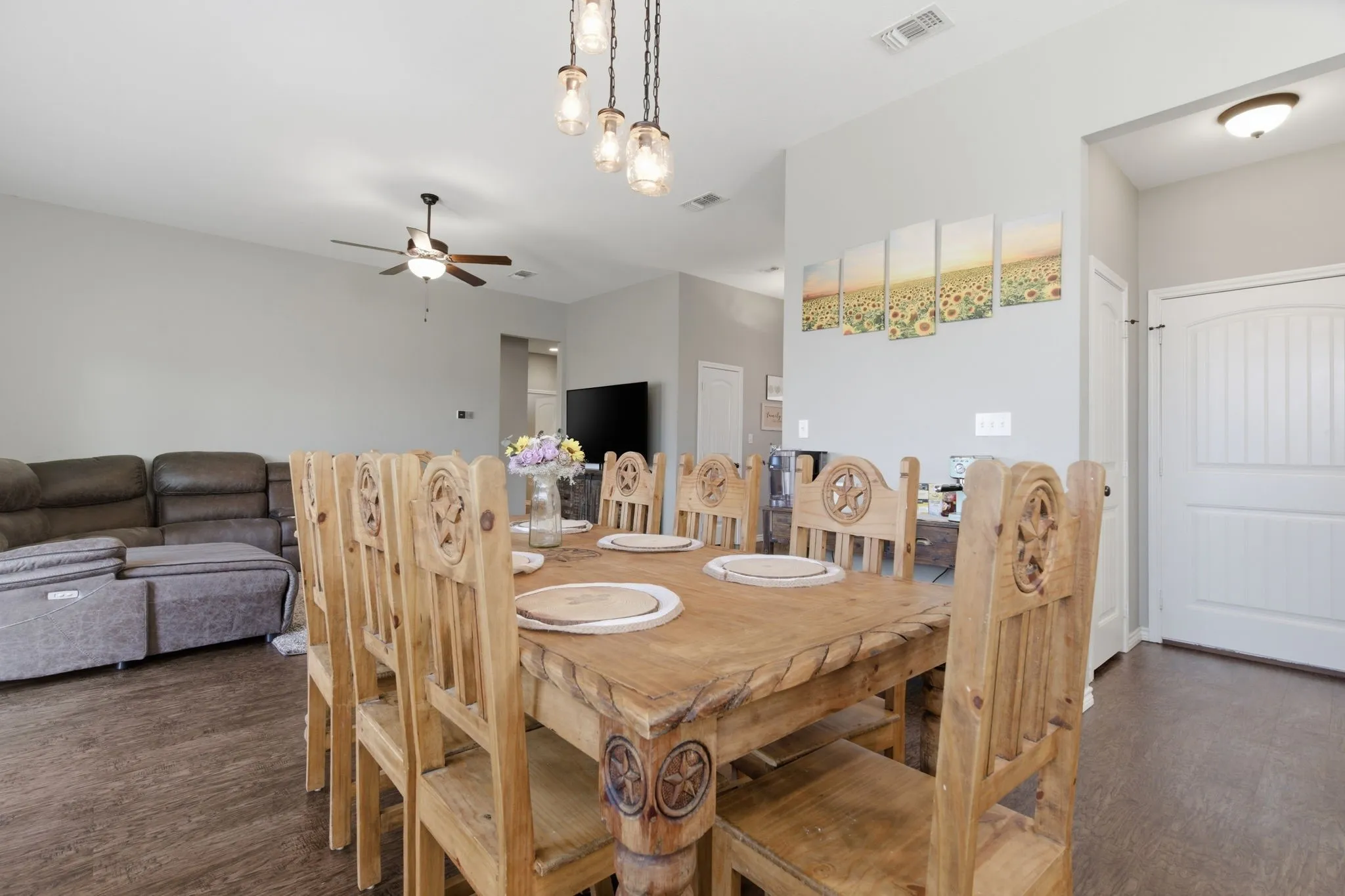 Dining space featuring ceiling fan and dark wood-style flooring