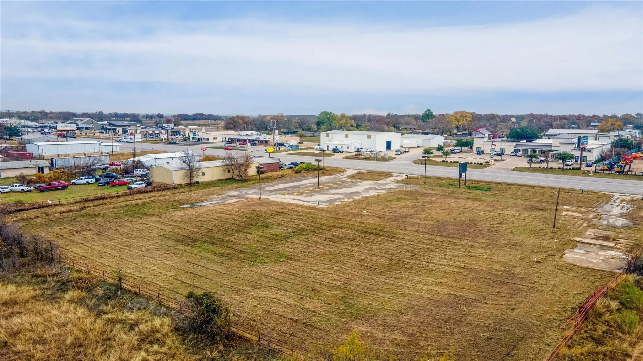Expansive open land area with surrounding commercial buildings