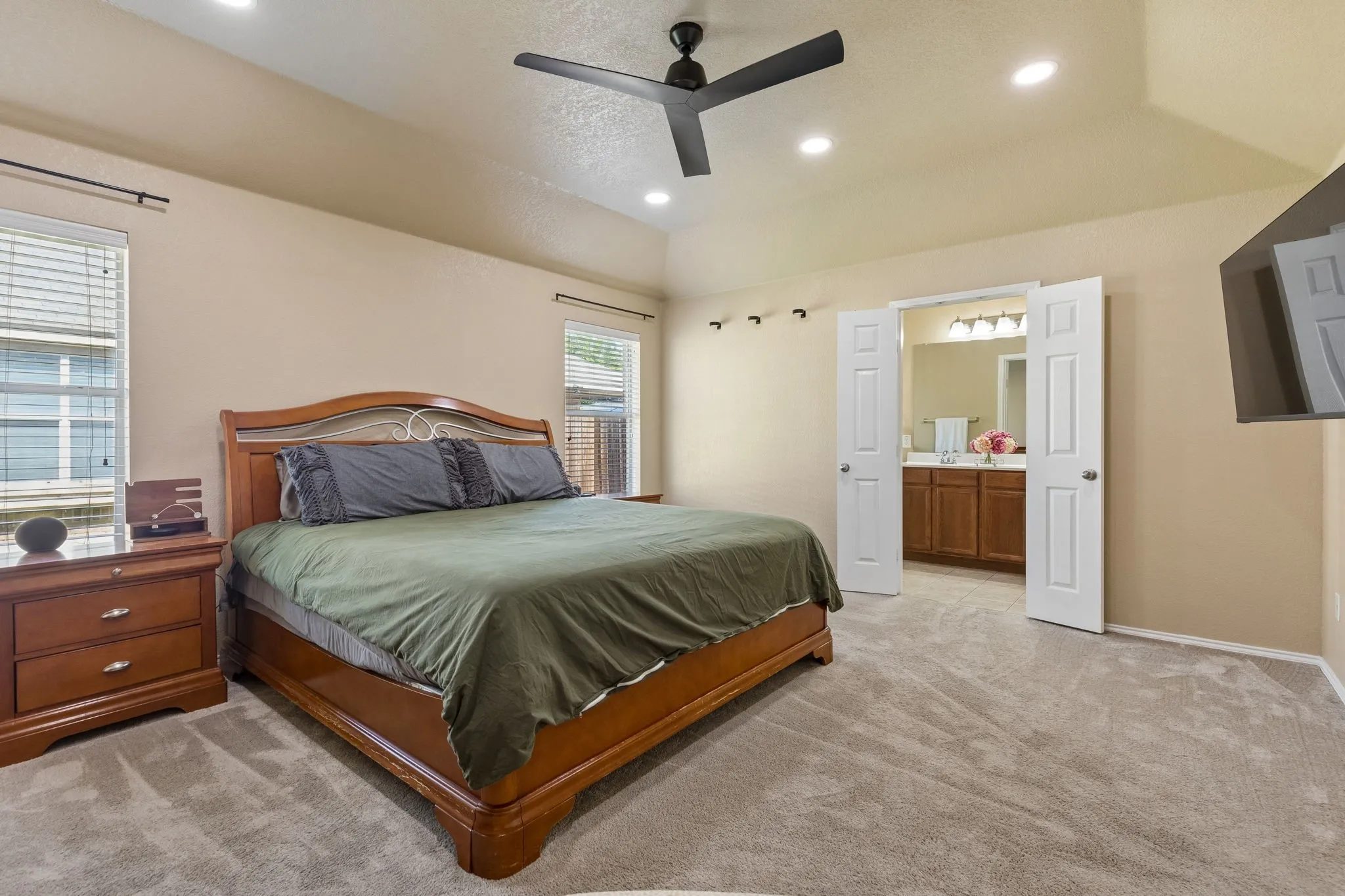 Primary suite with view of double doors leading into primary bathroom