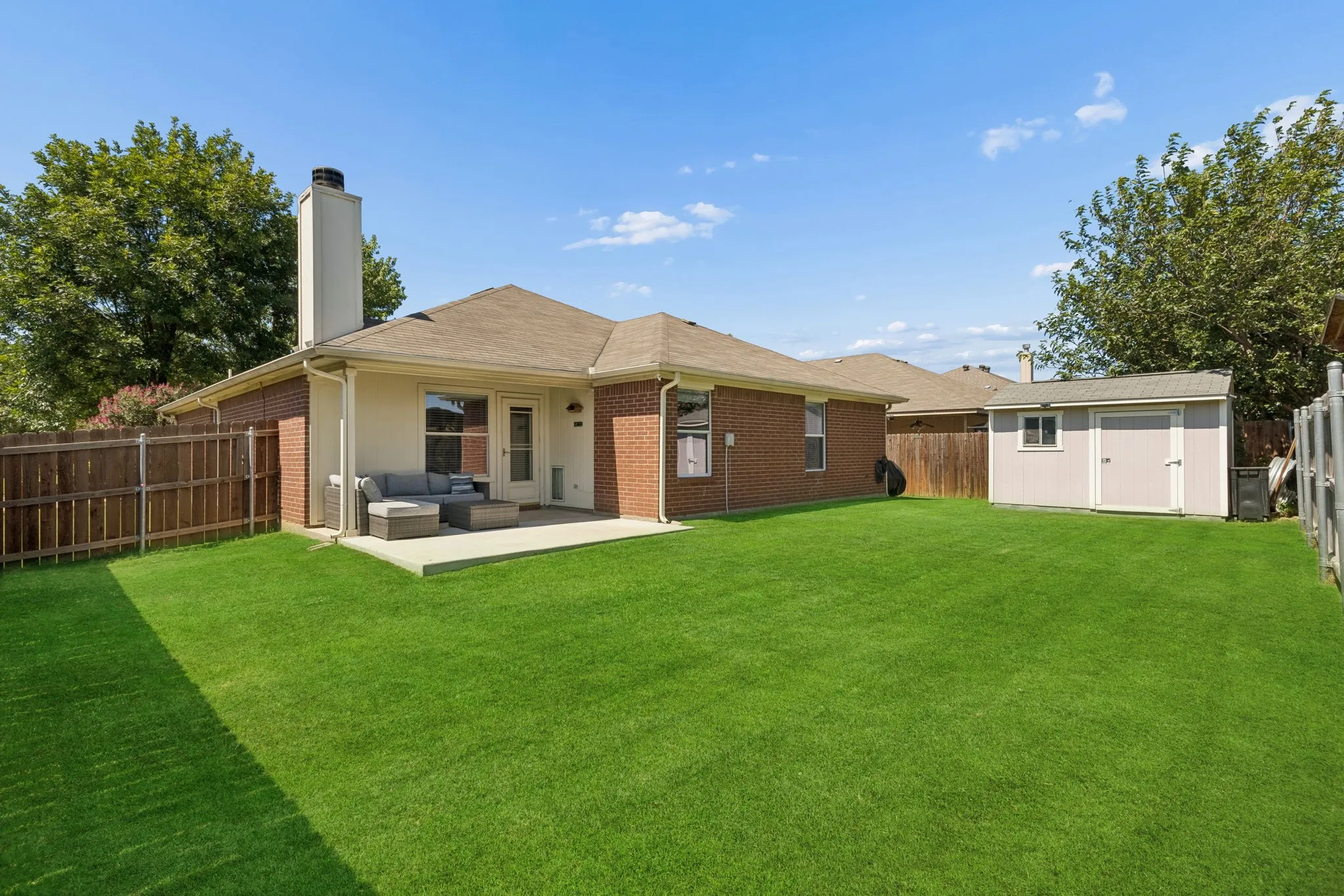 Back of home highlighting extended patio and shed
