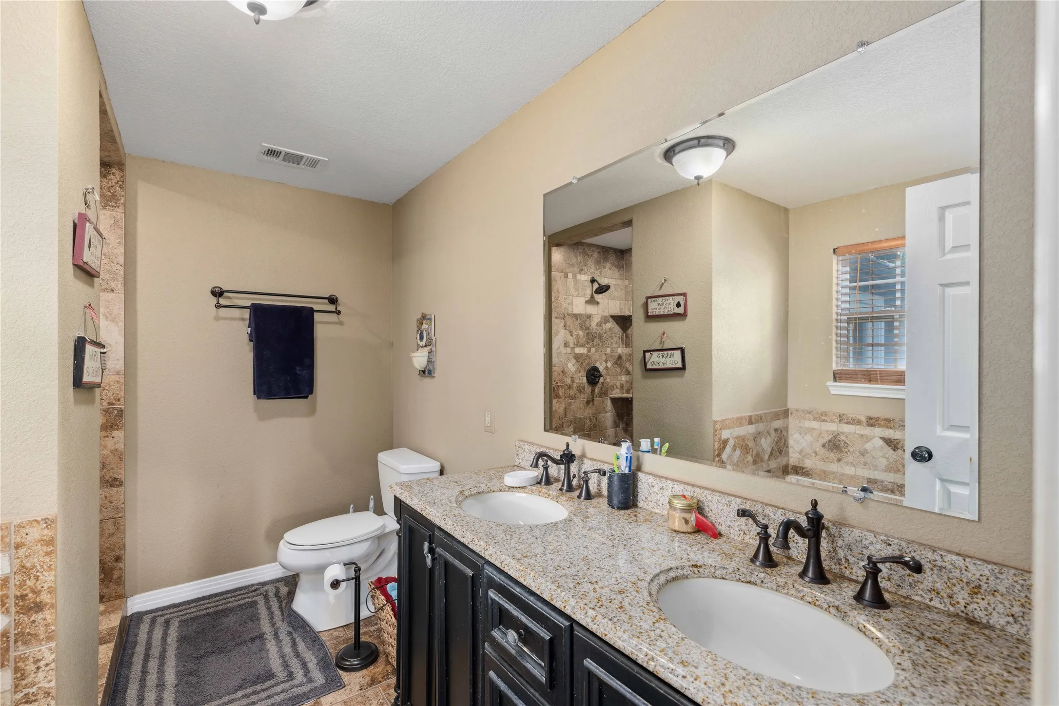 Primary bath room with jacuzzi tub, walk in shower and double sink vanity.