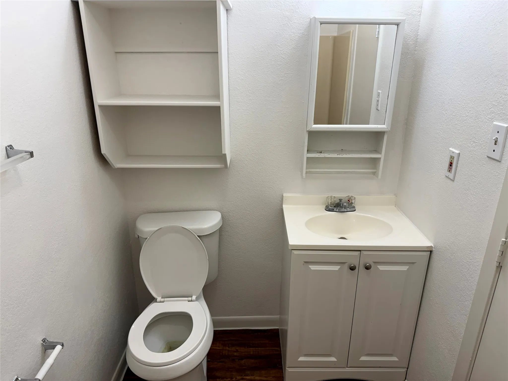 Bathroom with a white vanity featuring a single basin sink, white shaker-style cabinet doors, and a medicine cabinet with integrated mirror
