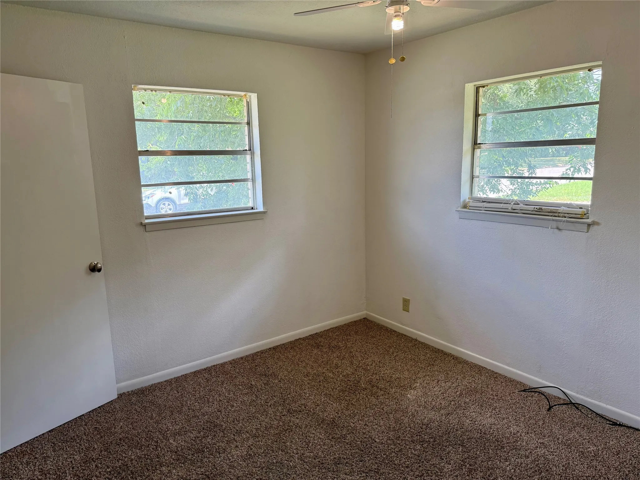 Neutral wall tones complement the brown carpeted flooring