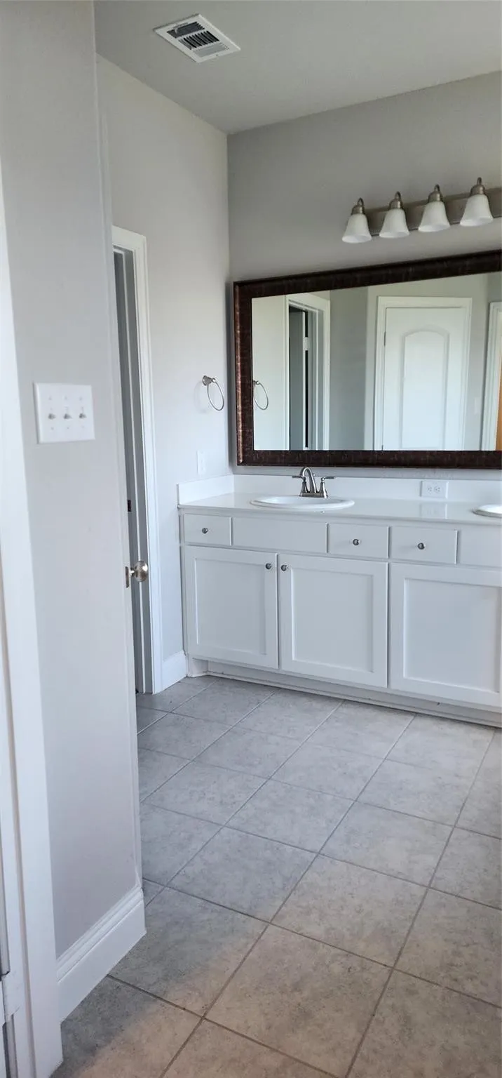 Dual vanity with white cabinetry, light-toned countertop, and undermount sinks