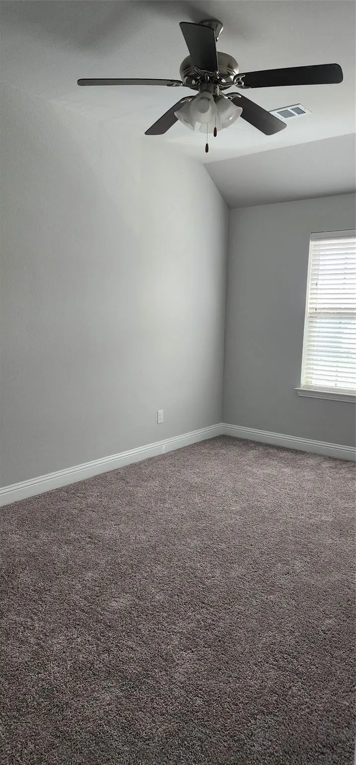 Room featuring plush carpeting, light-toned walls, and a ceiling fan with integrated lighting
