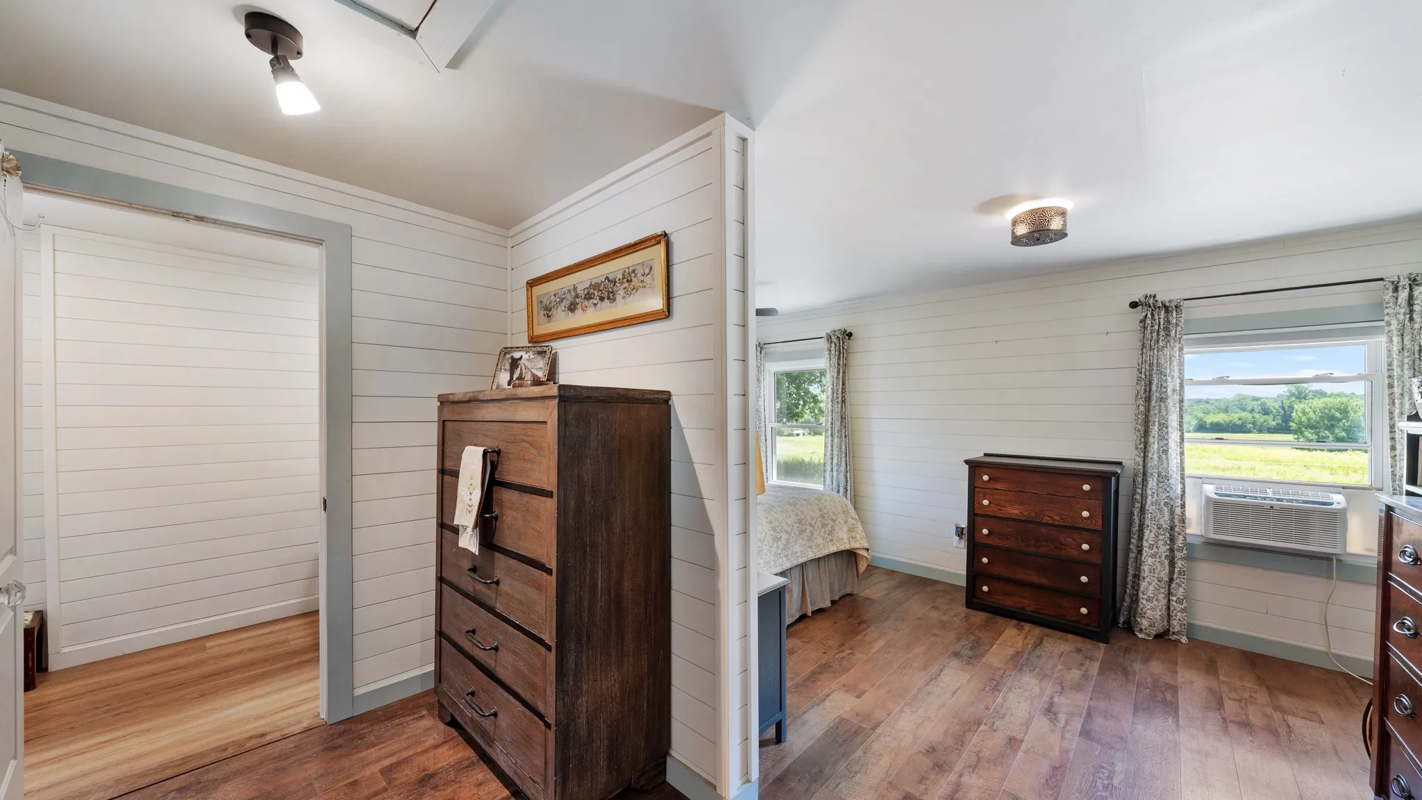 Room featuring wood-finish flooring, white shiplap walls, and a white ceiling