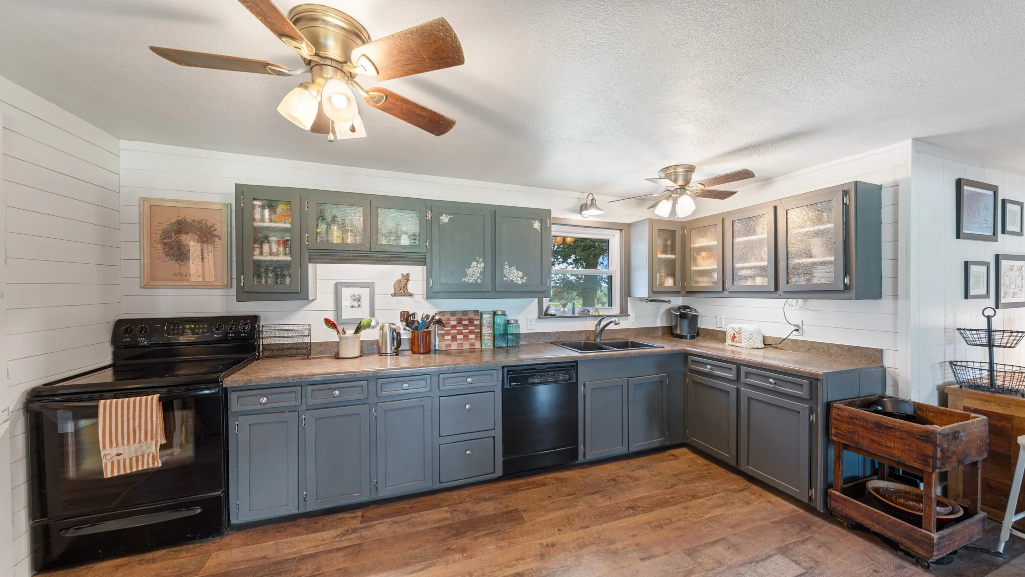 Kitchen featuring wood-finish flooring and a white shiplap wall