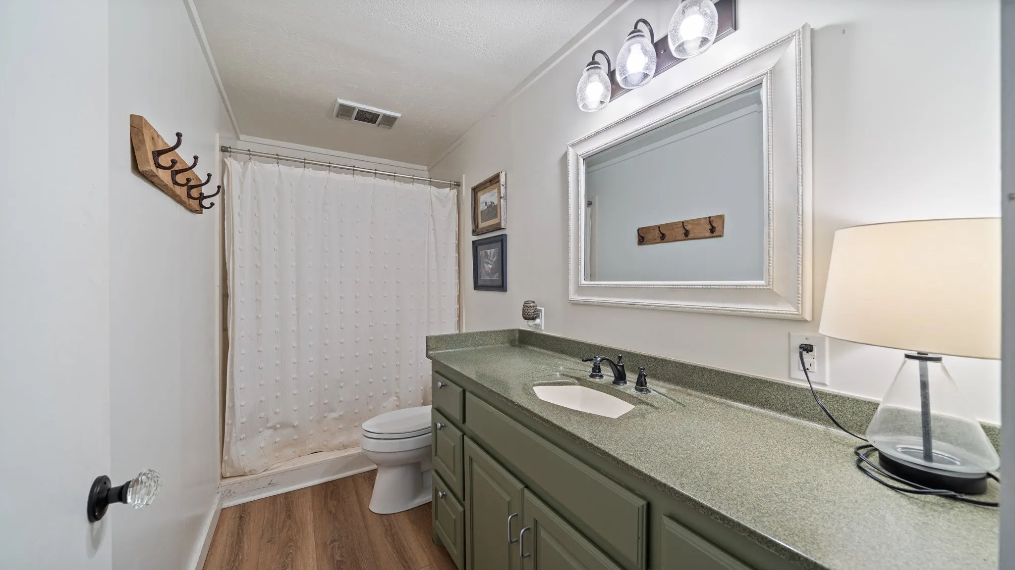 Bathroom featuring a wood-finish floor and a shower-tub combination