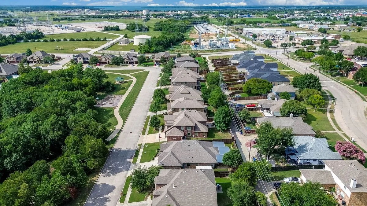 Aerial perspective showcasing residential properties with a mix of brick and siding exteriors
