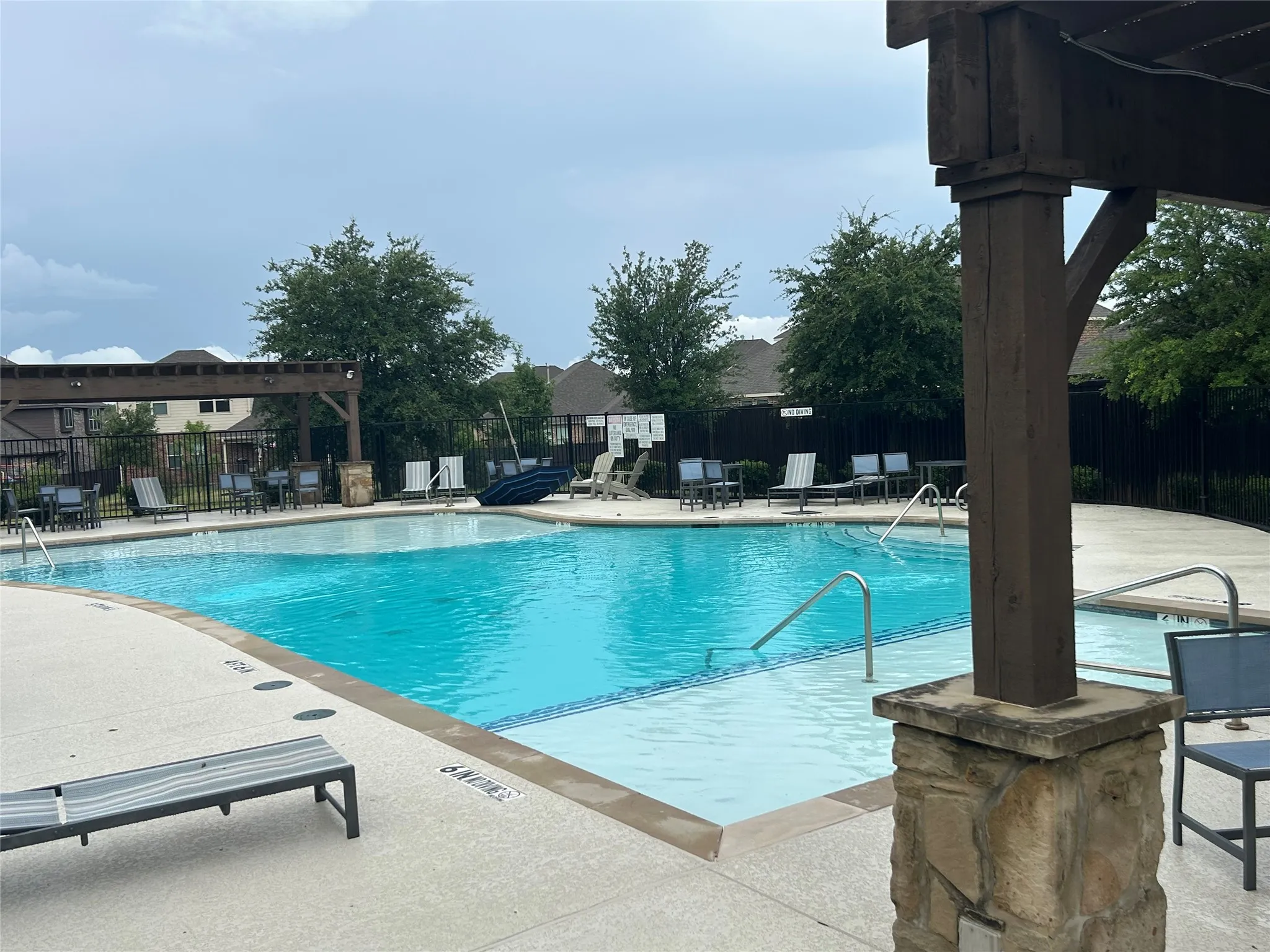 Community swimming pool featuring a curved design with integrated steps and perimeter handrails