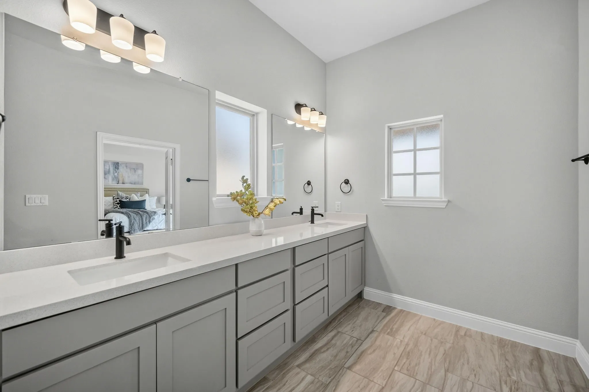 Double vanity featuring dual undermount sinks, stone countertops, and matte black fixtures
