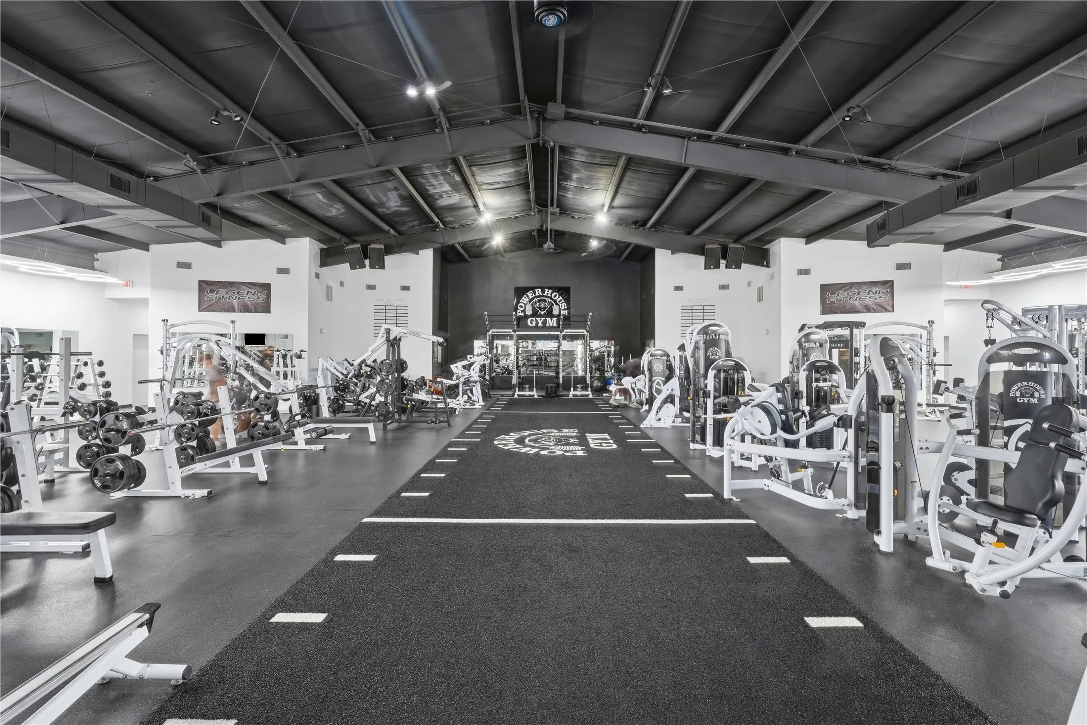 Expansive interior space featuring a textured black rubber flooring system with a central turf track