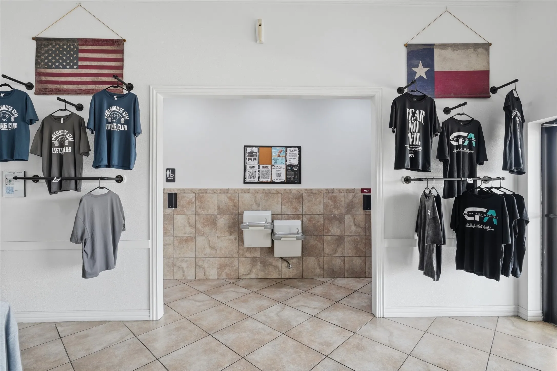 Tiled flooring with a diagonal pattern extends through a doorway, featuring a wainscoted wall with natural stone-look tile