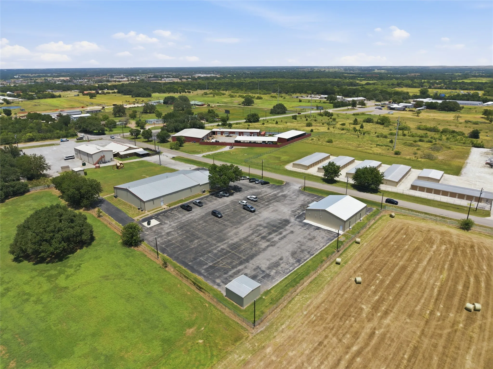 Aerial perspective highlighting commercial properties with expansive paved parking areas