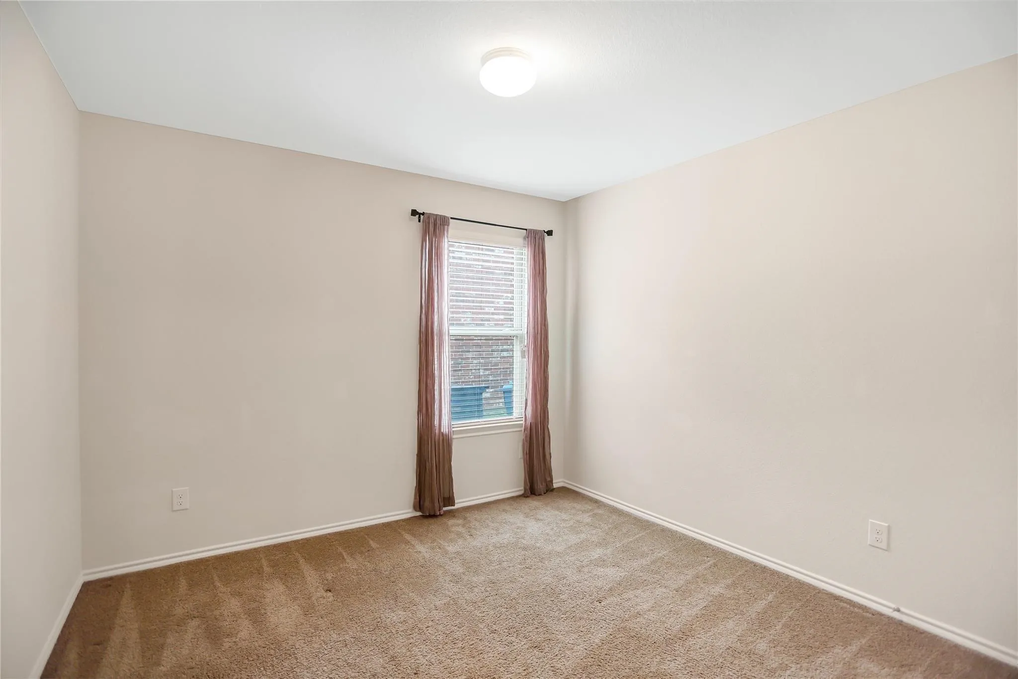 Neutral-toned walls complement the brown carpet flooring and white baseboards