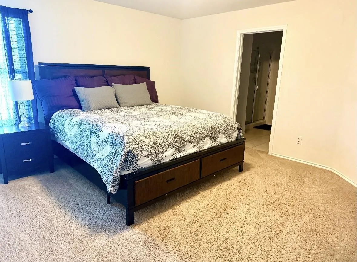 Wall-to-wall carpeting throughout this room with a doorway leading to a tiled interior space