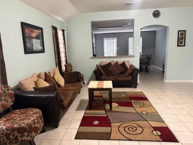 Ceramic tile flooring throughout, featuring a vaulted ceiling