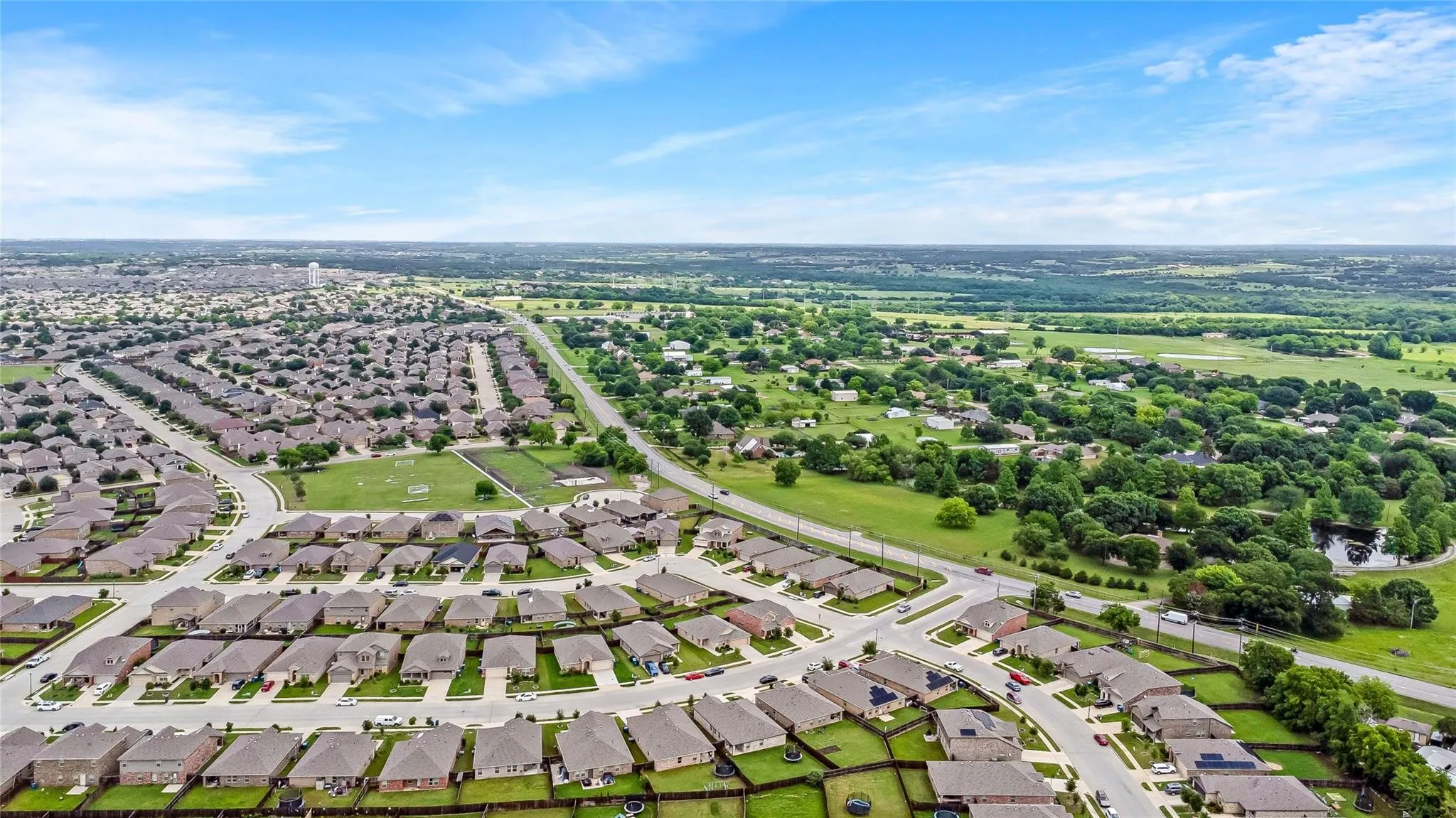 Expansive neighborhood featuring numerous residential properties with uniform rooflines and well-maintained lawns