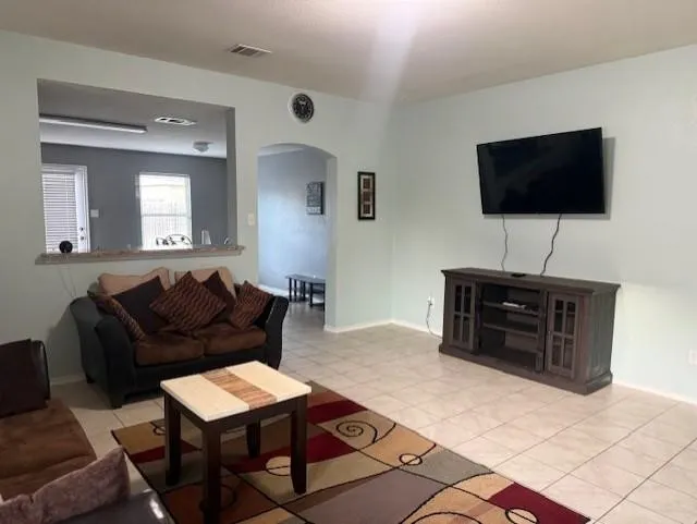 Spacious living area featuring tile flooring and light-toned walls