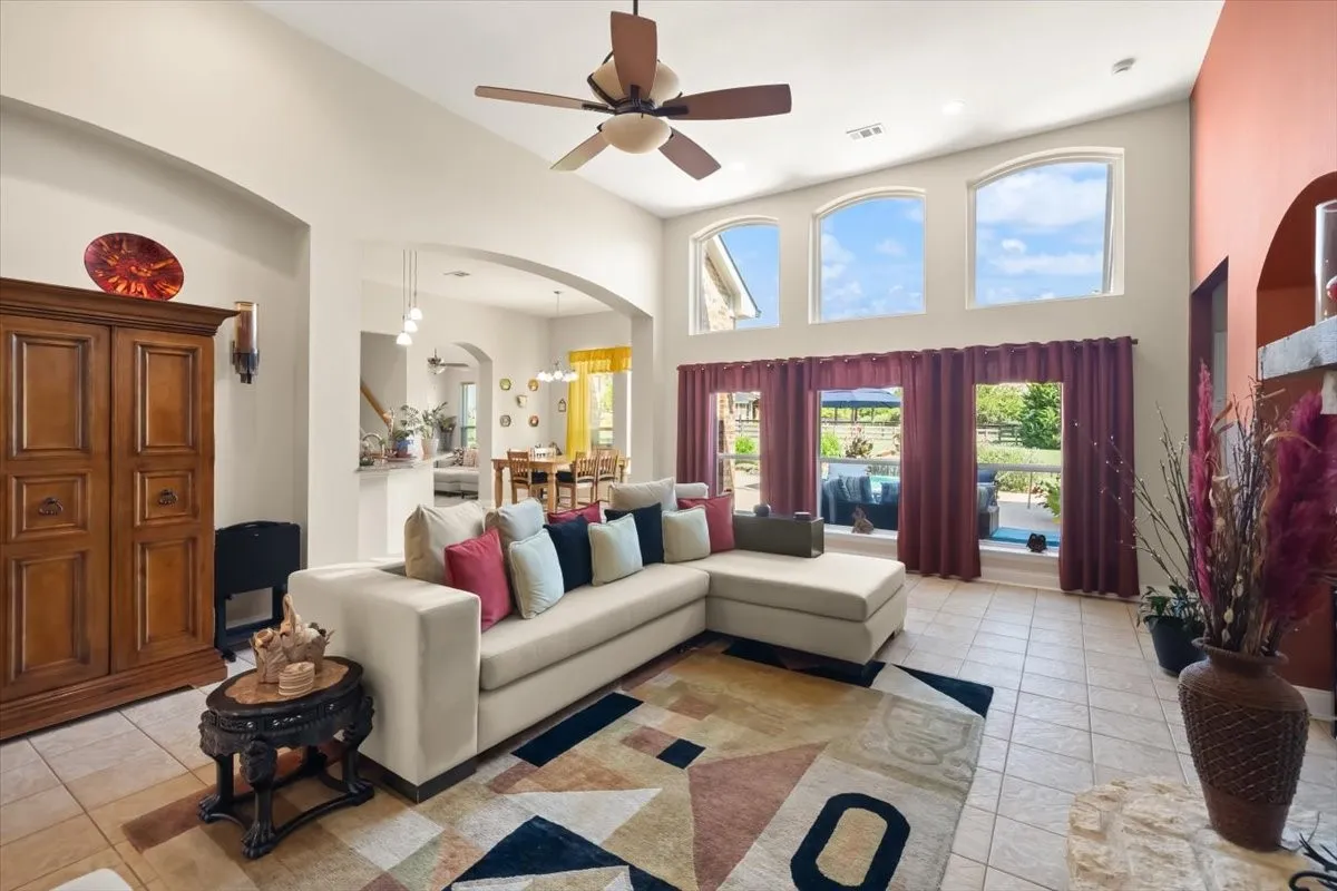 Vaulted ceilings complement the living area, featuring three arched windows and three large windows with direct exterior views