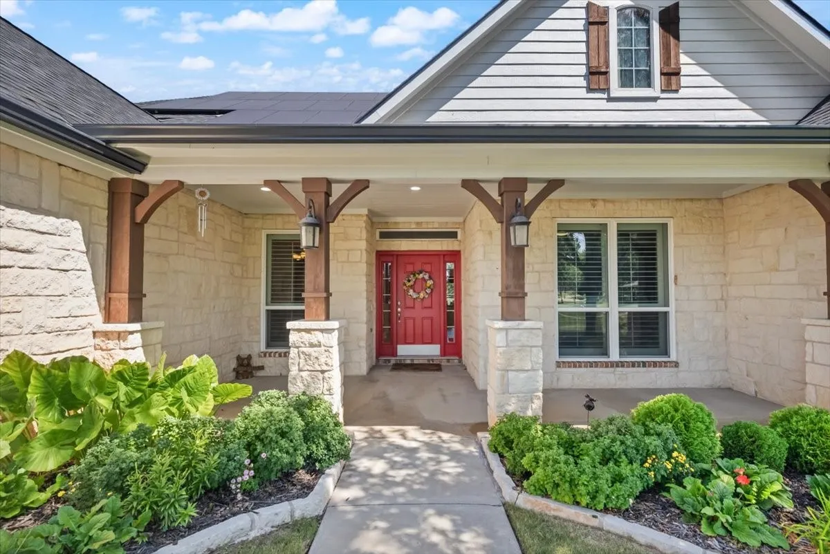 Stone and siding exterior featuring a covered front porch with substantial wood-finish columns on stone bases