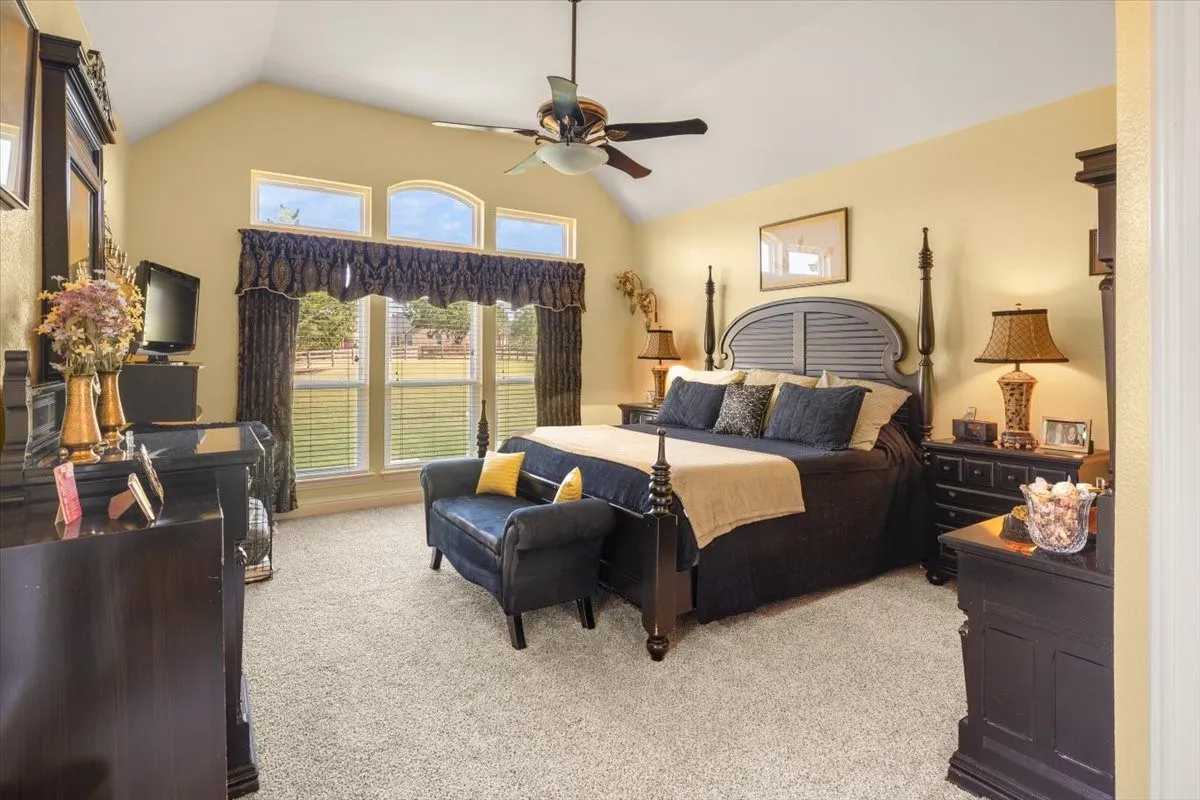 Vaulted ceiling bedroom with a ceiling fan
