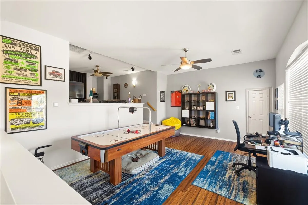 Loft area featuring wood-finish flooring and a ceiling fan